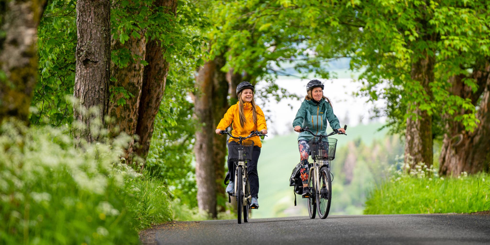 Two woman cycling among flowerfields at The Golden Road, Inderøy