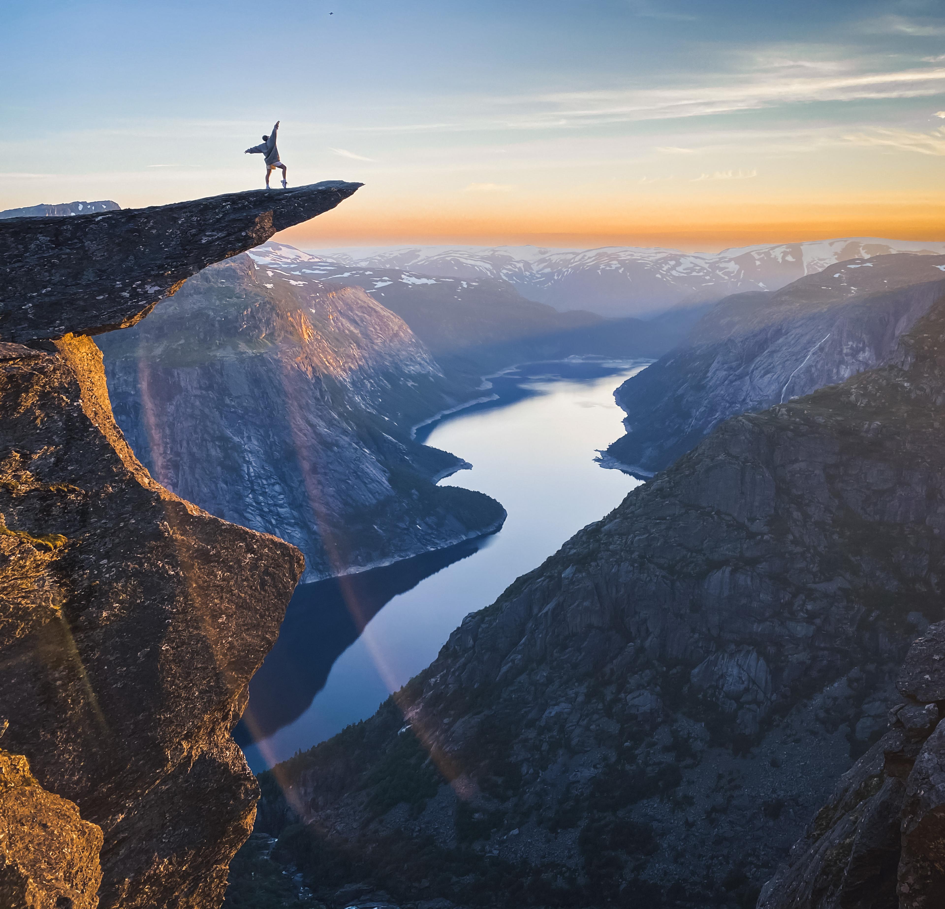 En person står på toppen av Trolltunga med utsikt over Ringedalsvatnet.