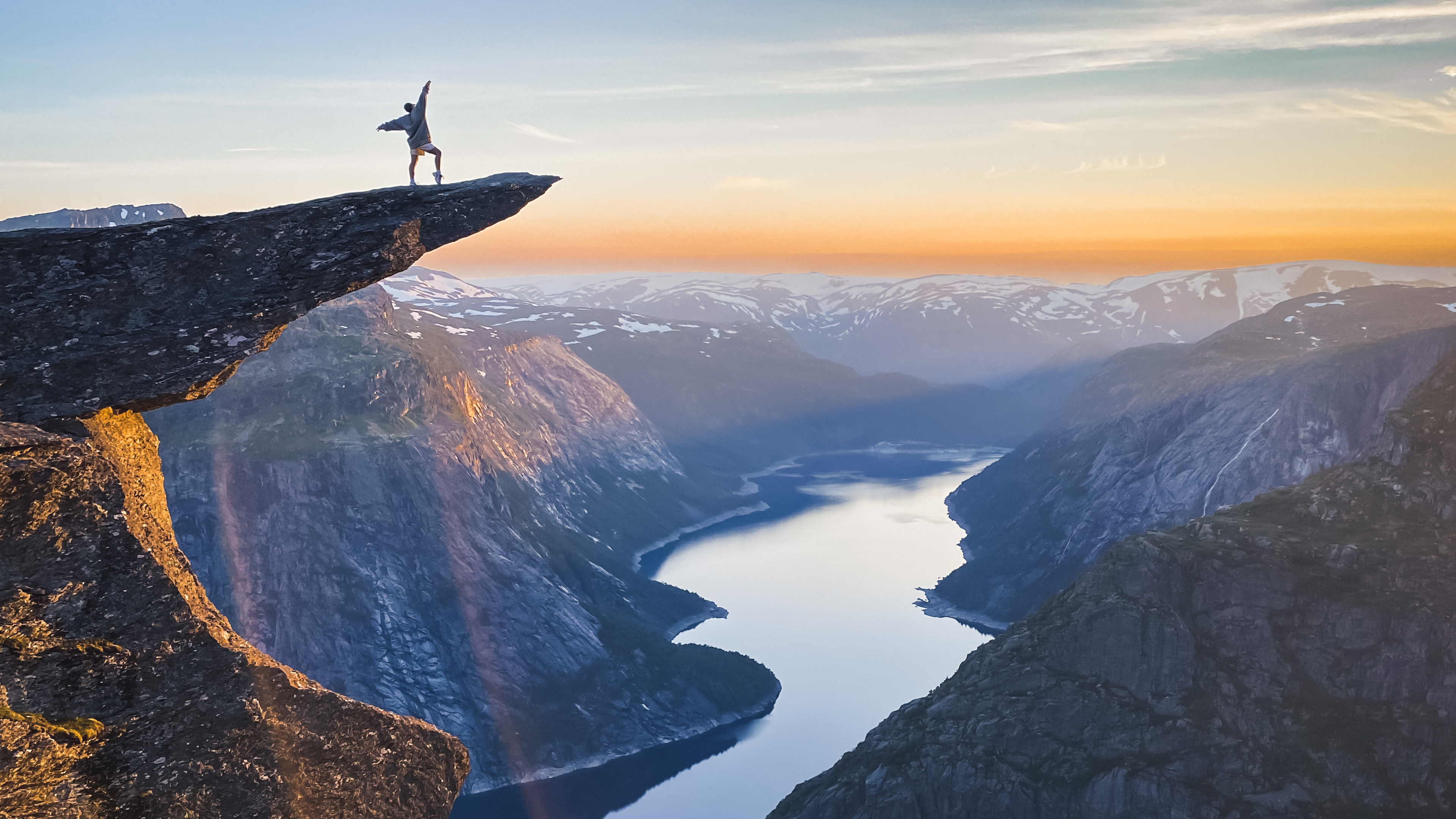 A person standing at Trolltunga overlooking Lake Ringedalsvatnet.