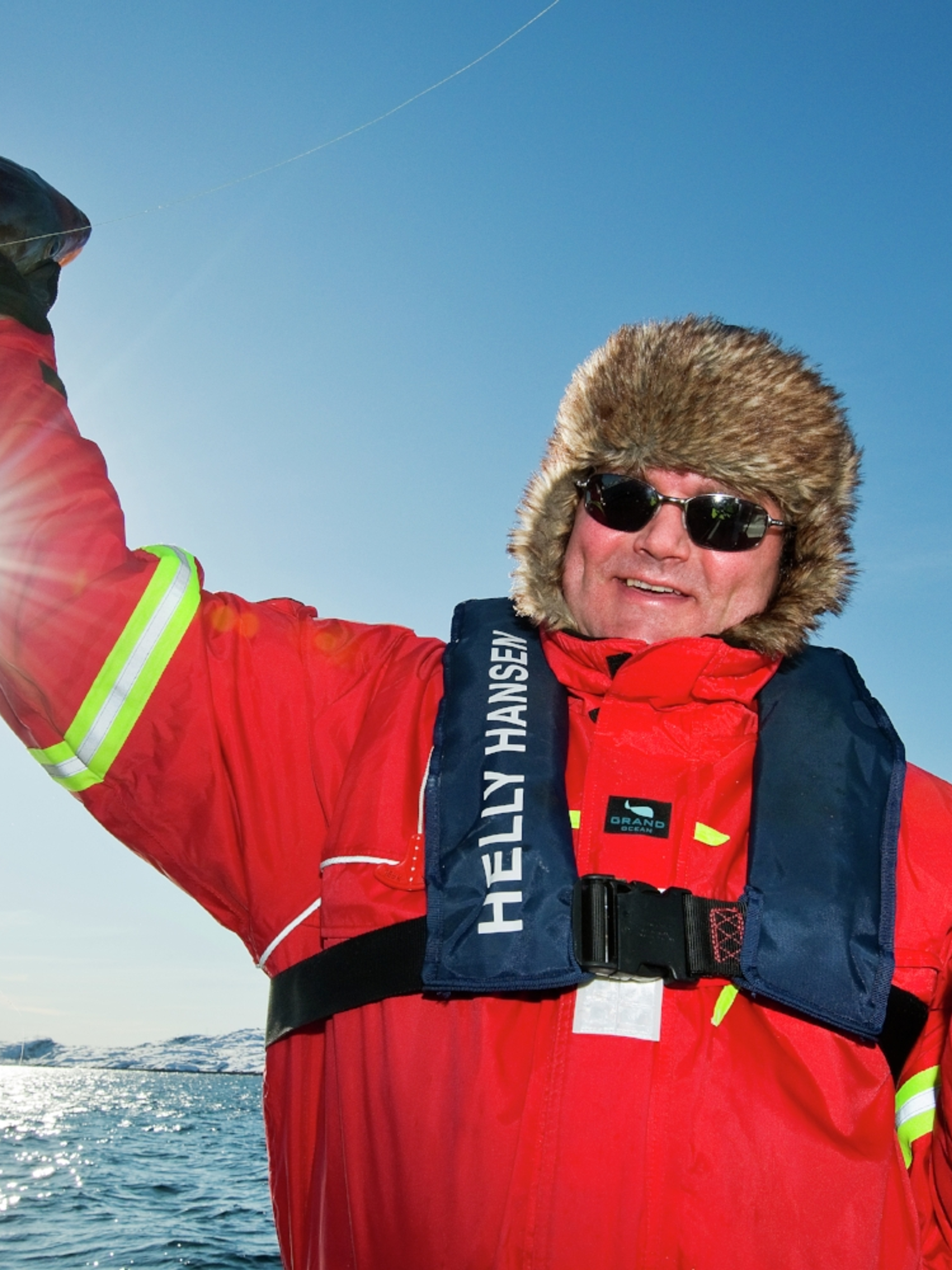 A man who has caught a fish in Austnesfjorden in Lofoten in Northern Norway