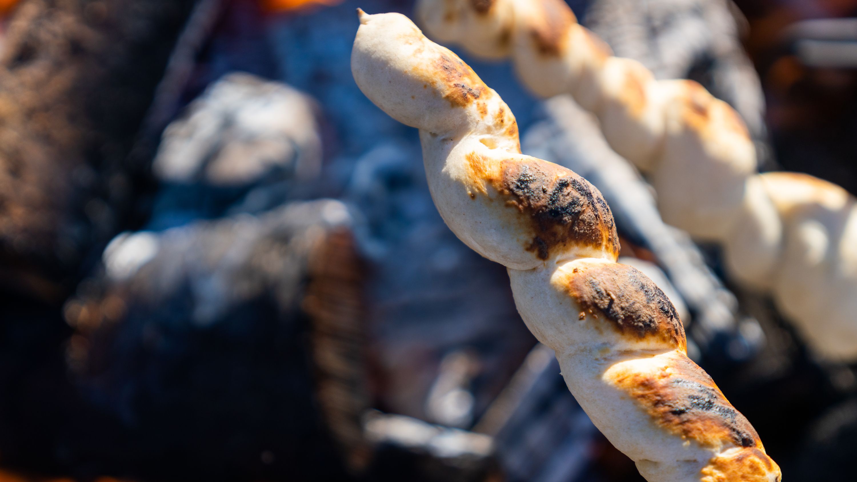 Pinnebrød being grilled at the campfire in the woods, Grefsenkollen, Norway