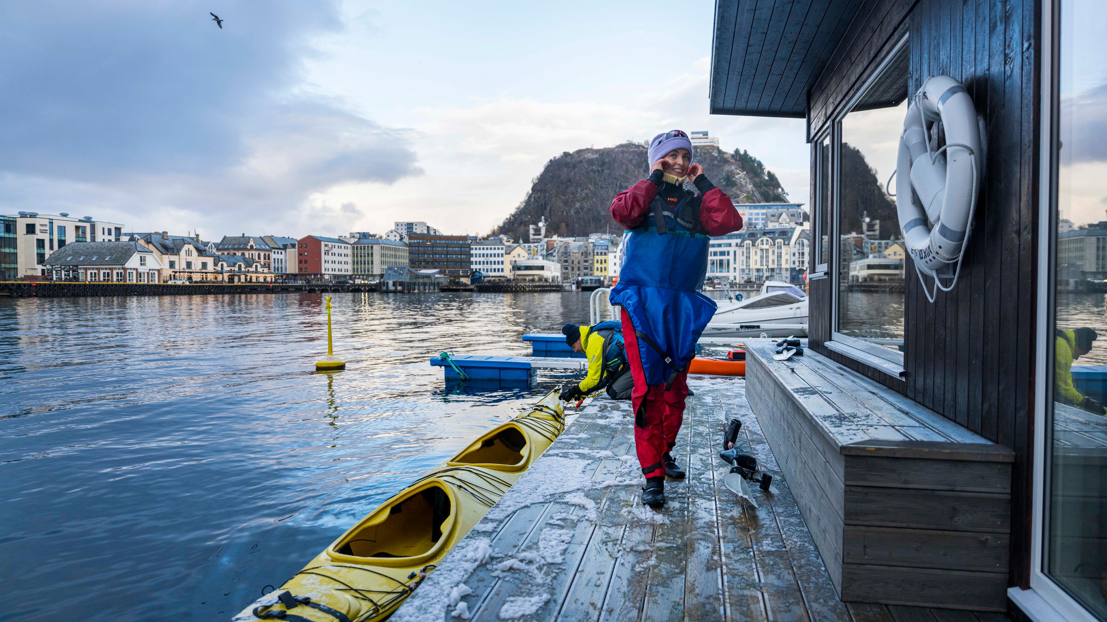 Woman embarking a kayak to swim from a sauna in Ålesund