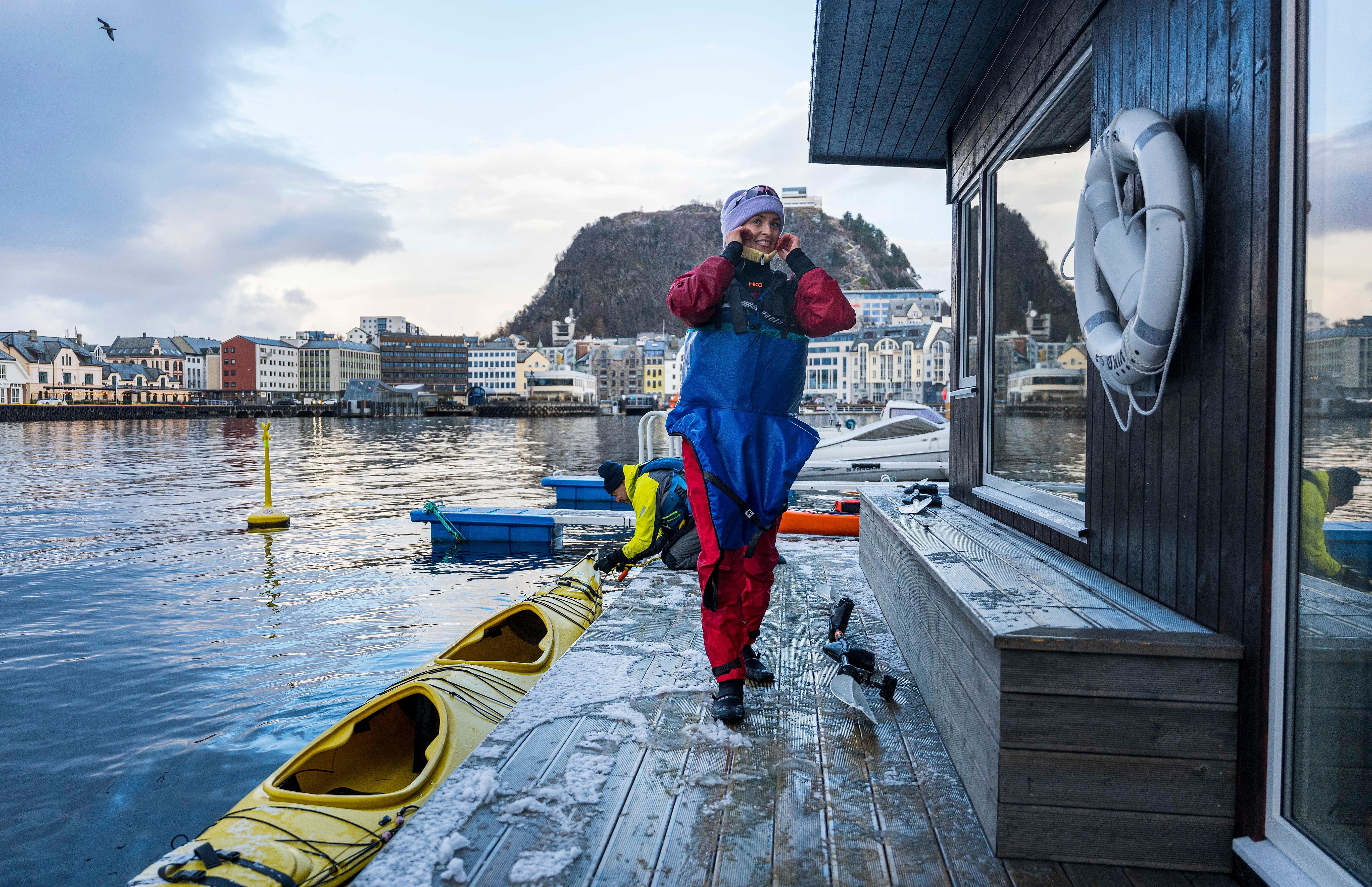 Woman embarking a kayak to swim from a sauna in Ålesund