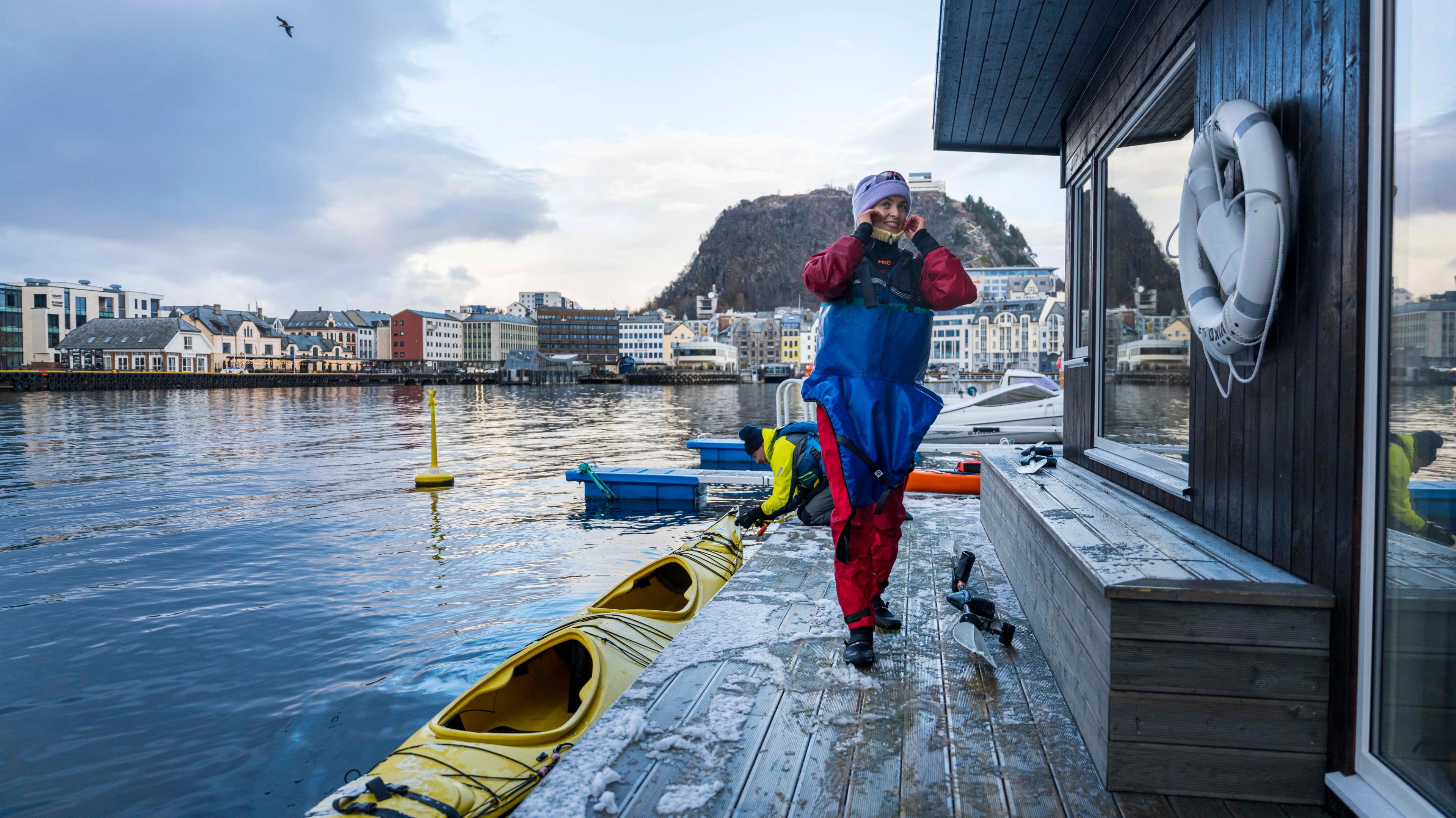 Woman embarking a kayak to swim from a sauna in Ålesund
