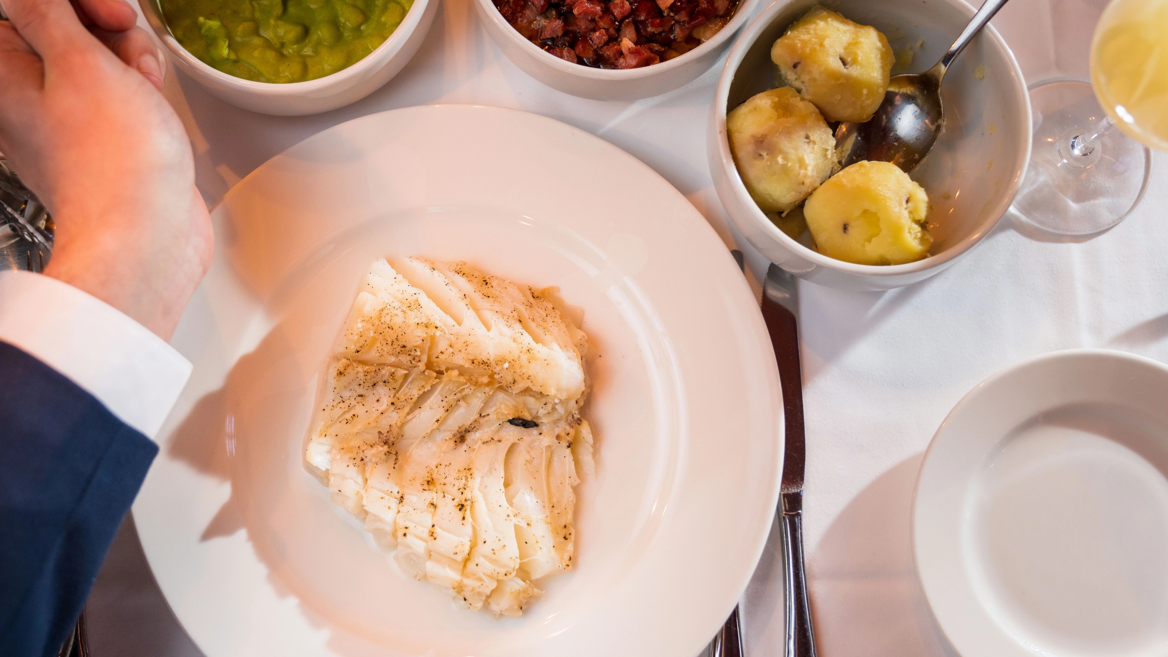 A serving of lutefisk with potatoes, bacon and pea stew