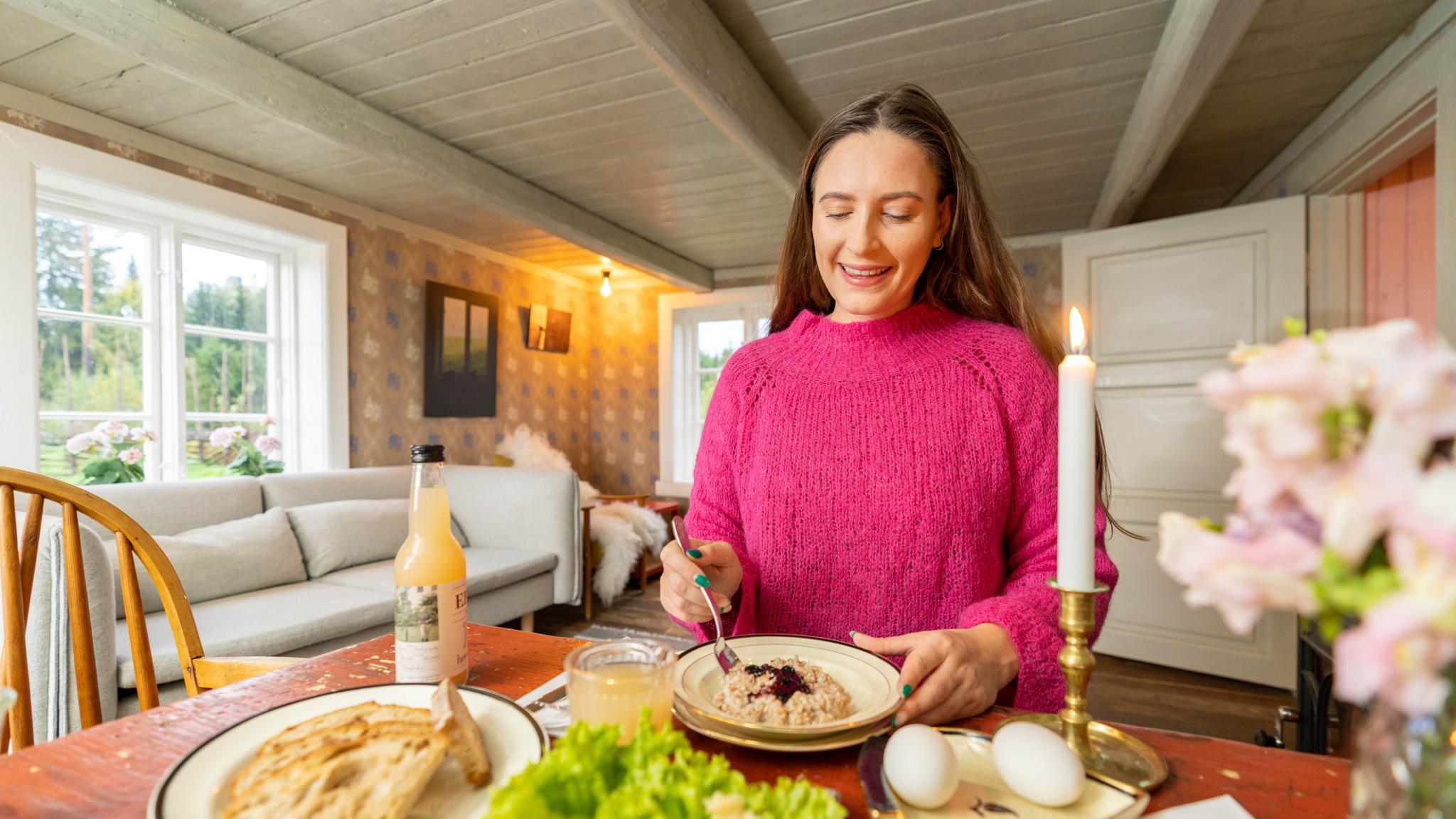 A woman eating breakfast at the Villa Leonore at Hovelsrud farm in the Hamar region, Eastern Norway