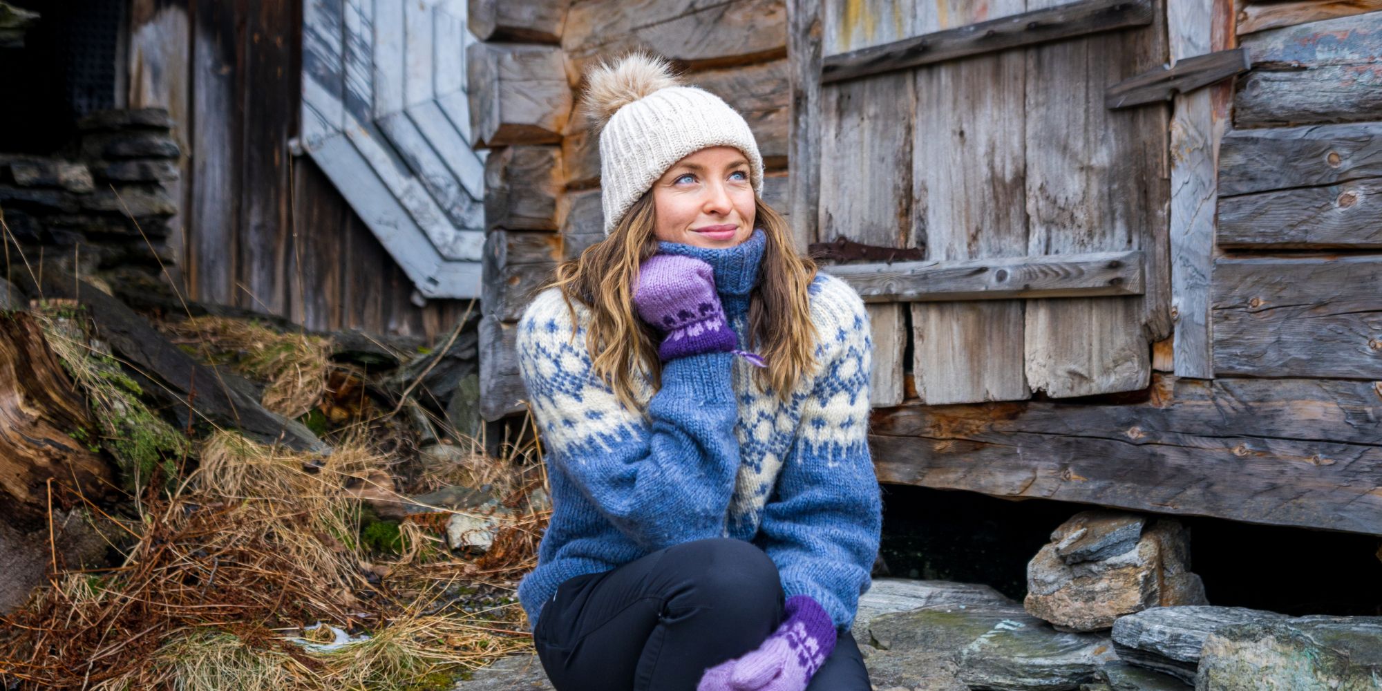 Woman sitting in some stone stairs by the harbor in Geiranger