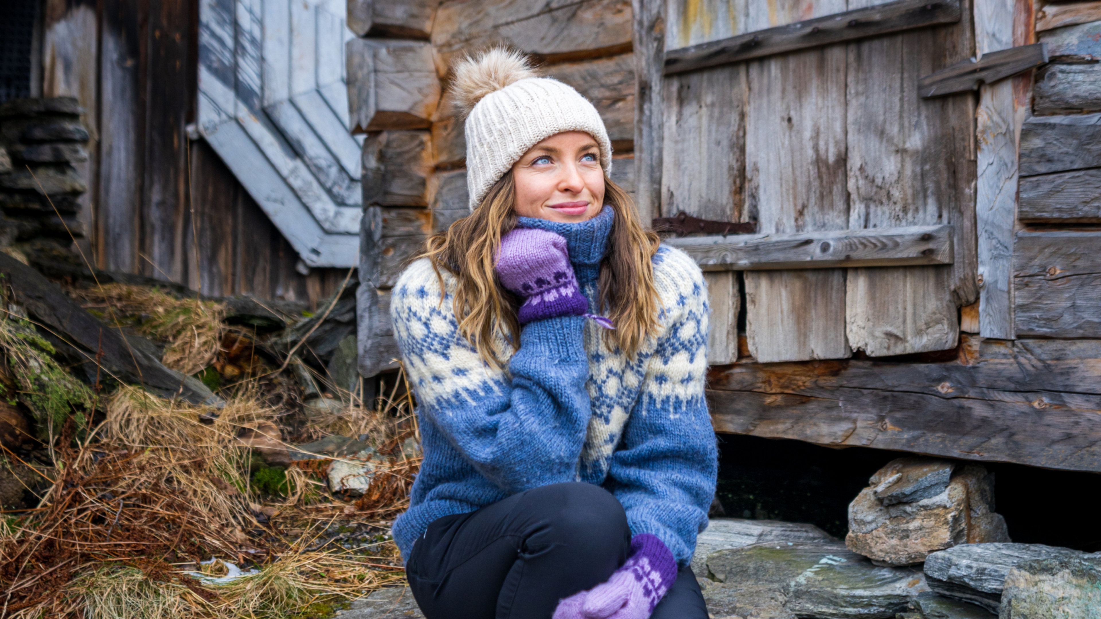 Woman sitting in some stone stairs by the harbor in Geiranger