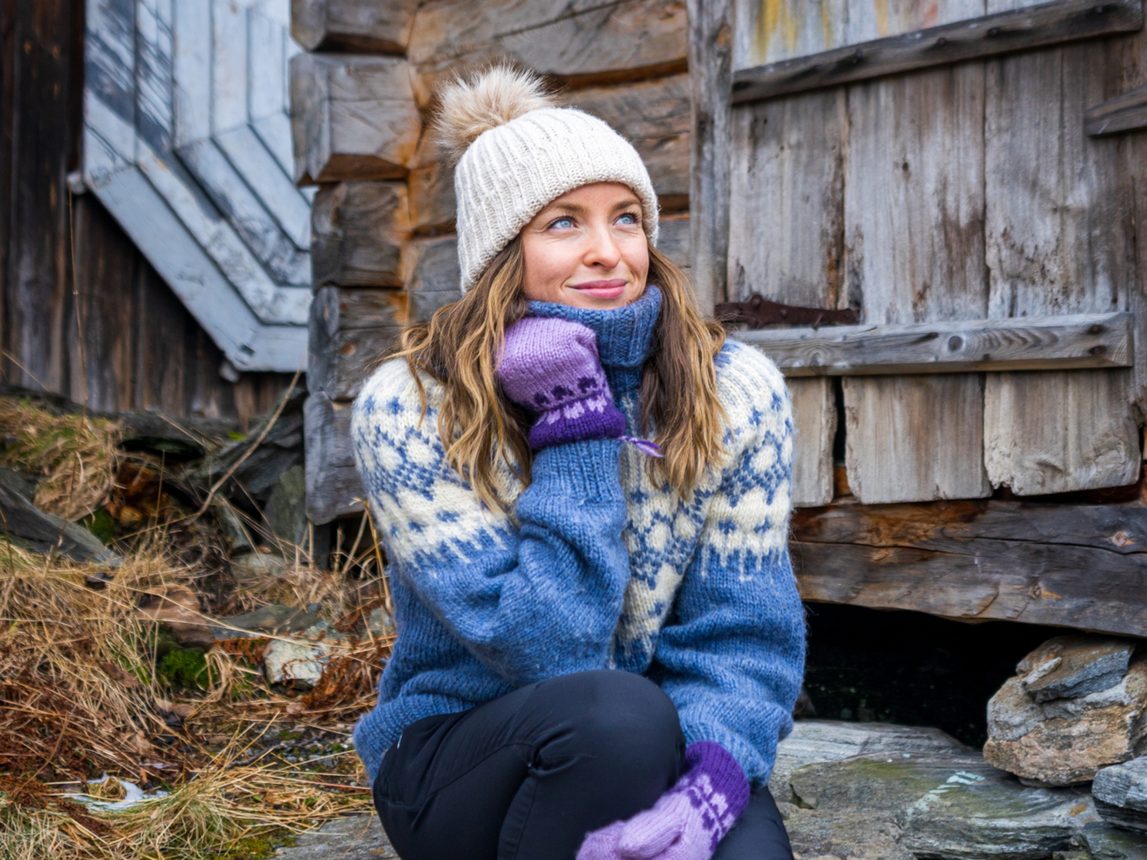 Woman sitting in some stone stairs by the harbor in Geiranger