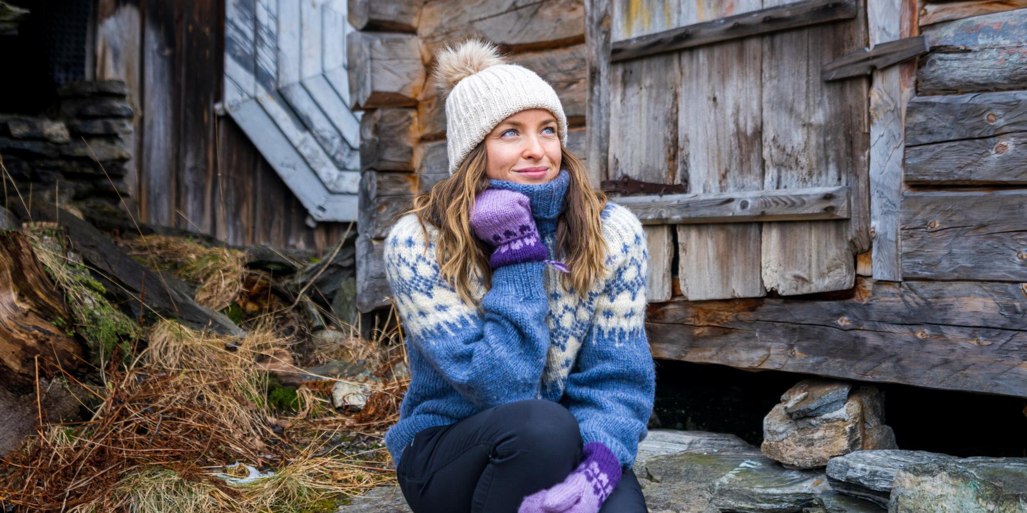 Woman sitting in some stone stairs by the harbor in Geiranger