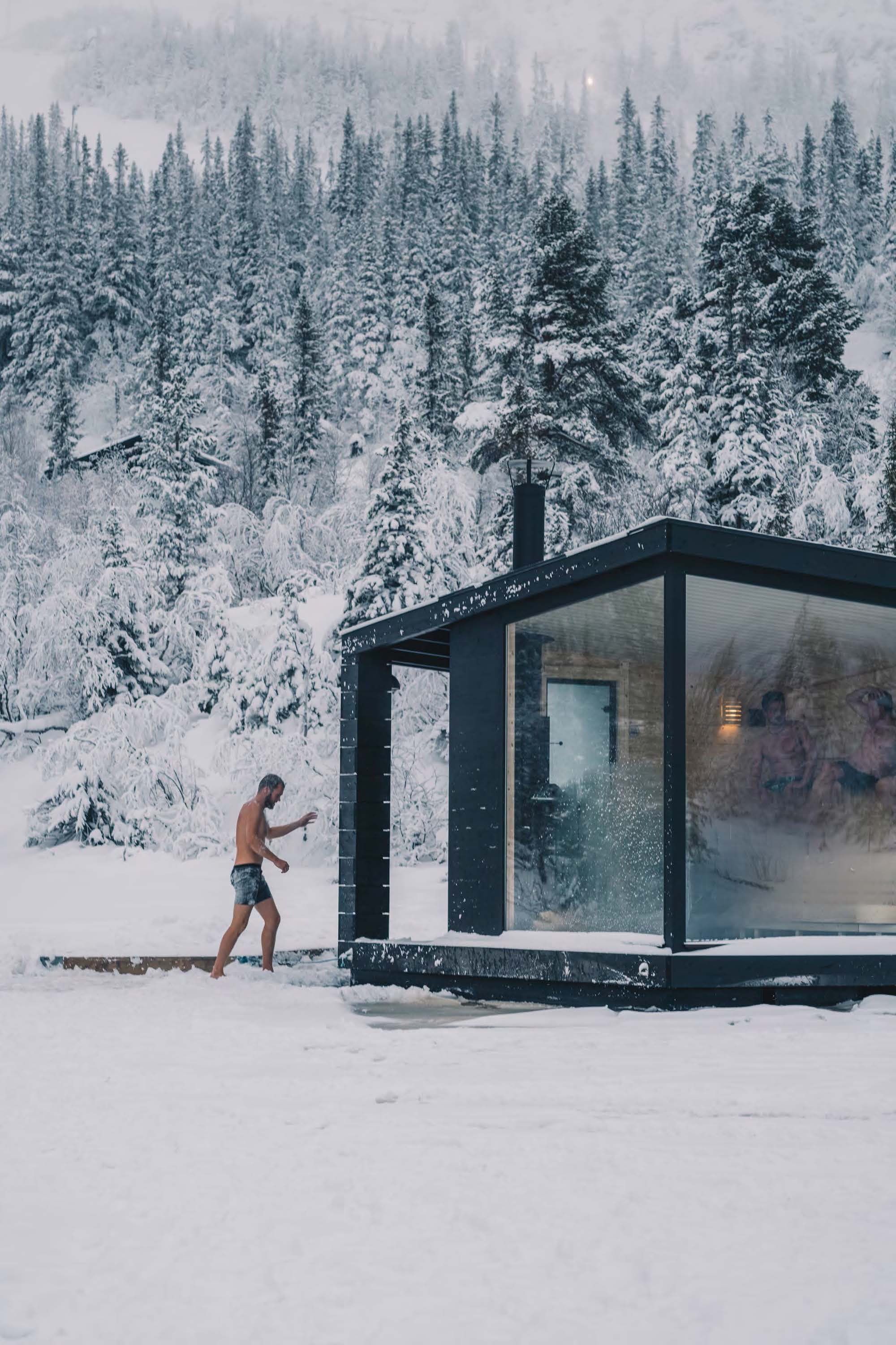 En person ved den flydende sauna om vinteren i Rjukan, Telemark i Norge