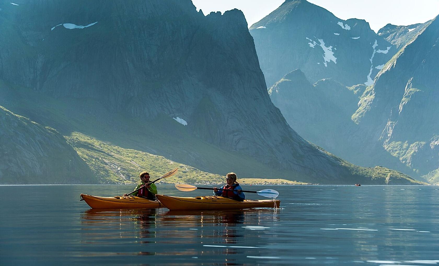 Couple kayaking in Reinefjorden, the Lofoten Islands