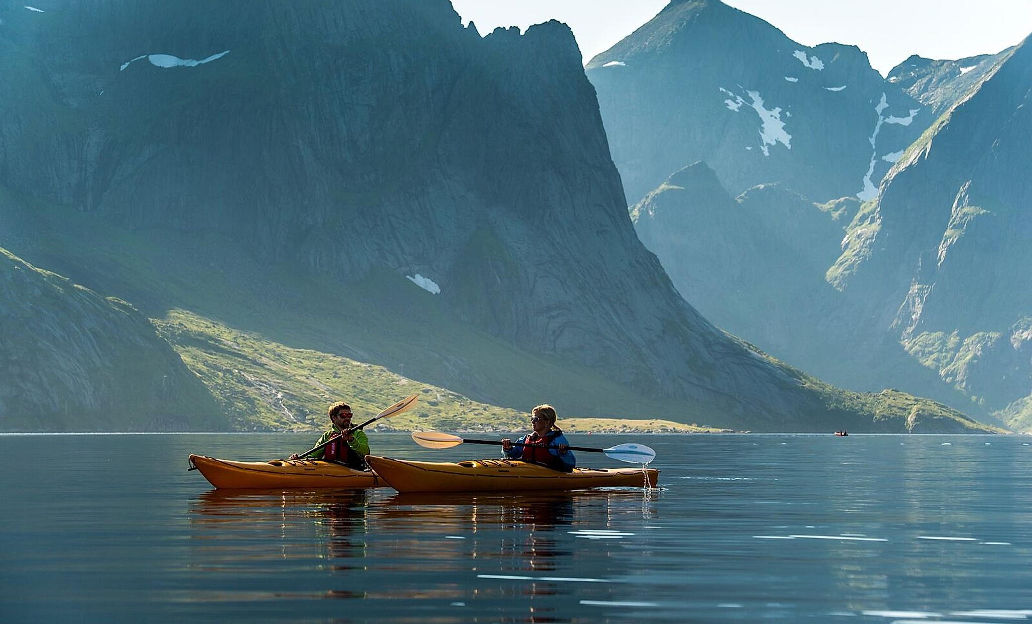 Couple kayaking in Reinefjorden, the Lofoten Islands