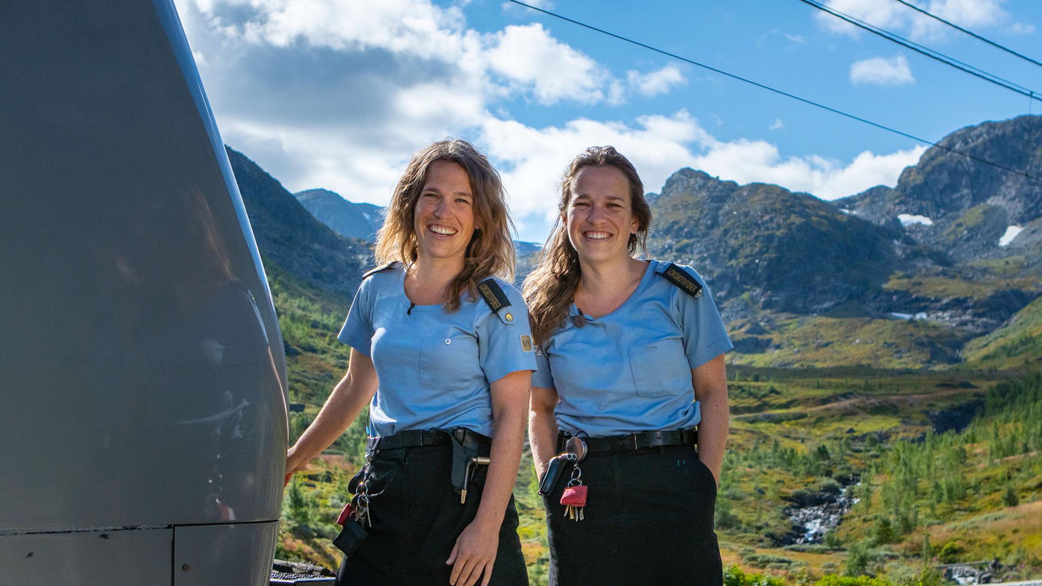 Two train drivers standing outside of the train along the Bergen Railway