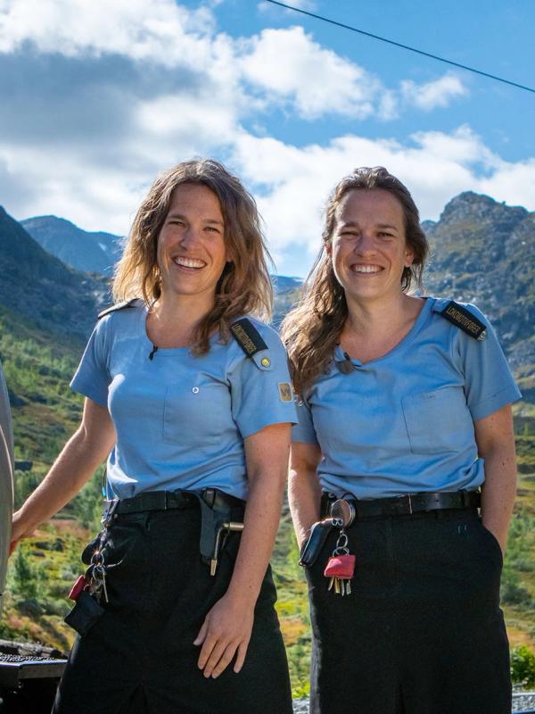 Two train drivers standing outside of the train along the Bergen Railway