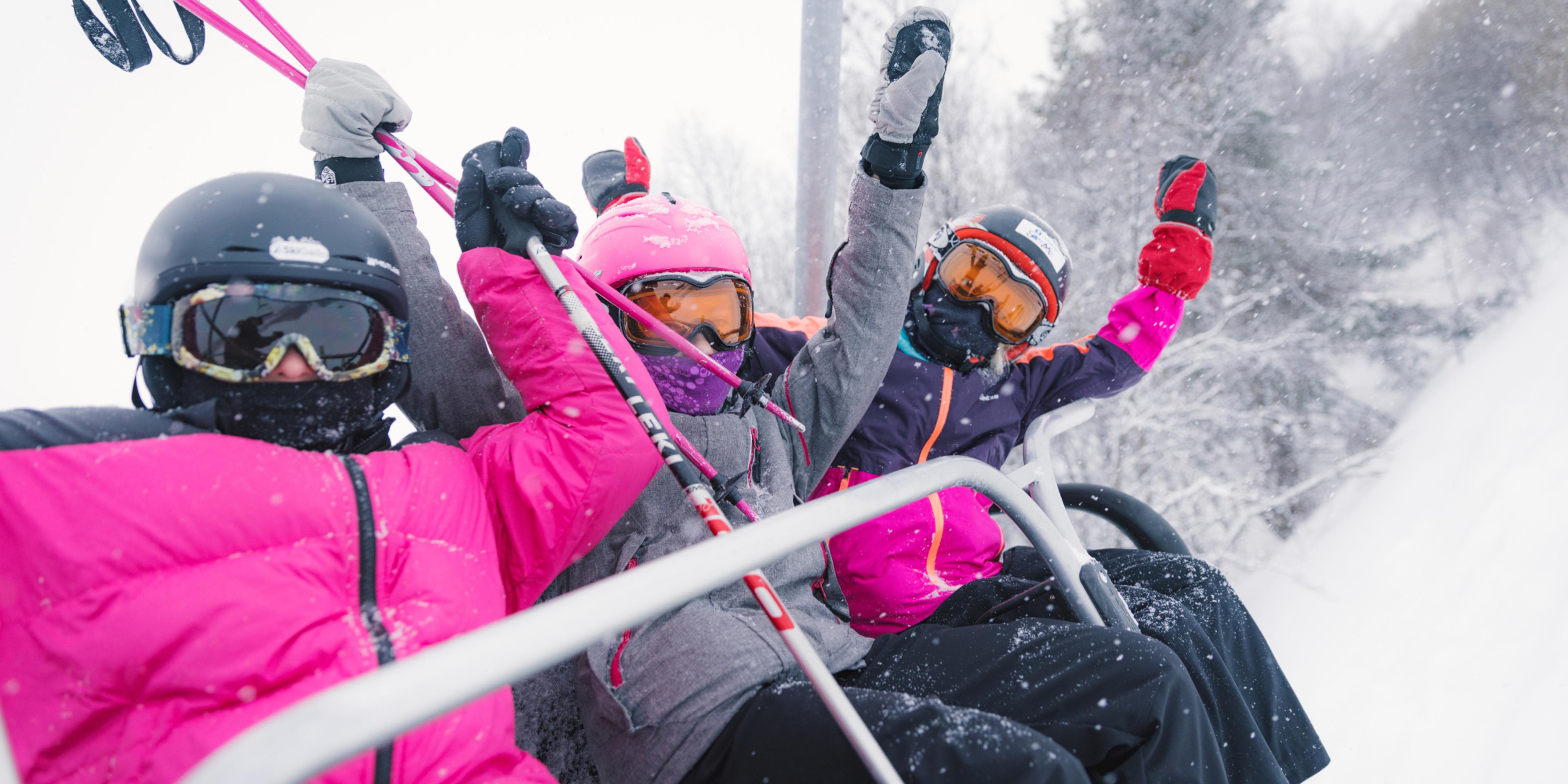 Three happy girls sitting in a ski lift in Geilo ski resort, Eastern Norway