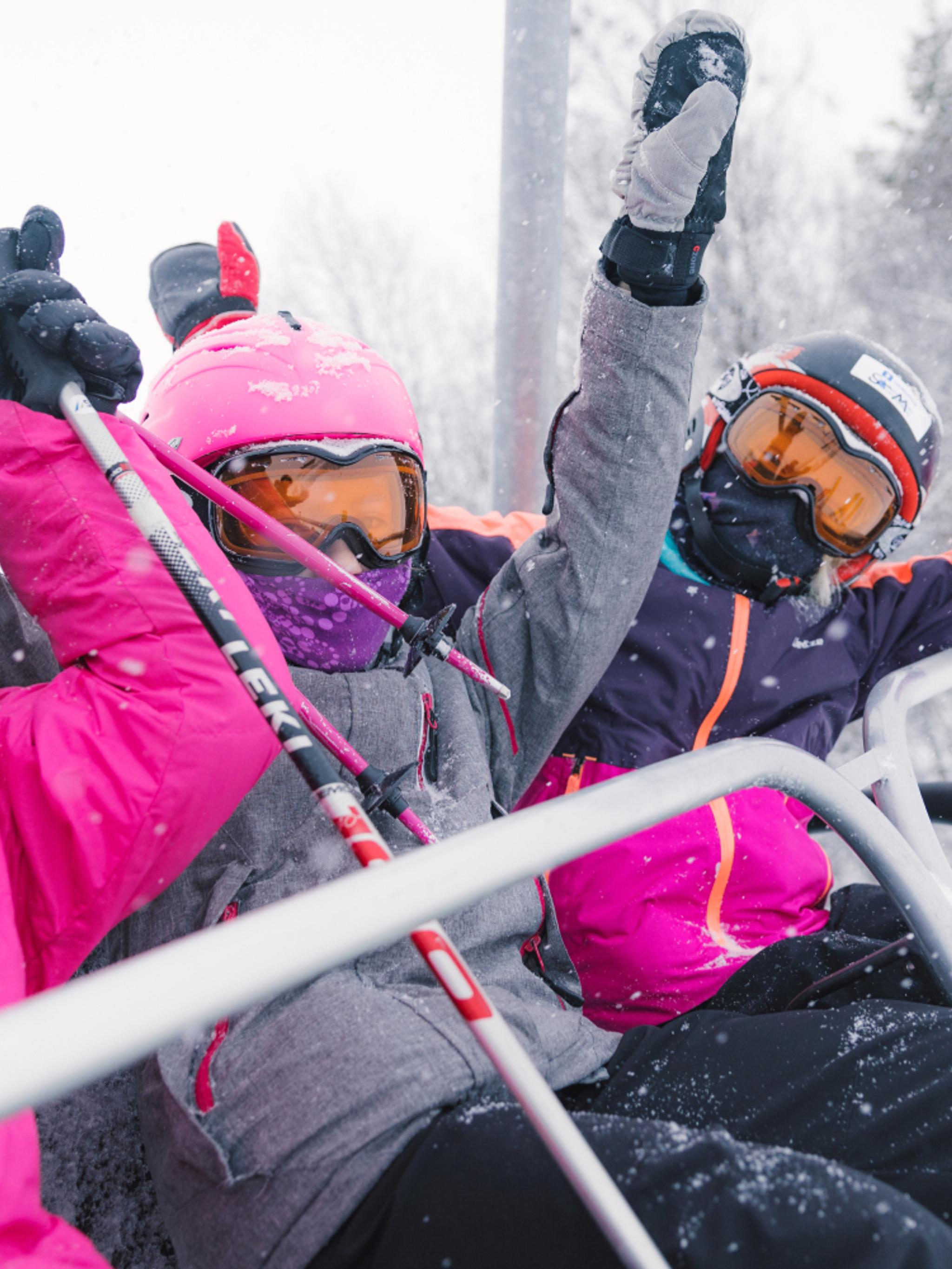 Three happy girls sitting in a ski lift in Geilo ski resort, Eastern Norway