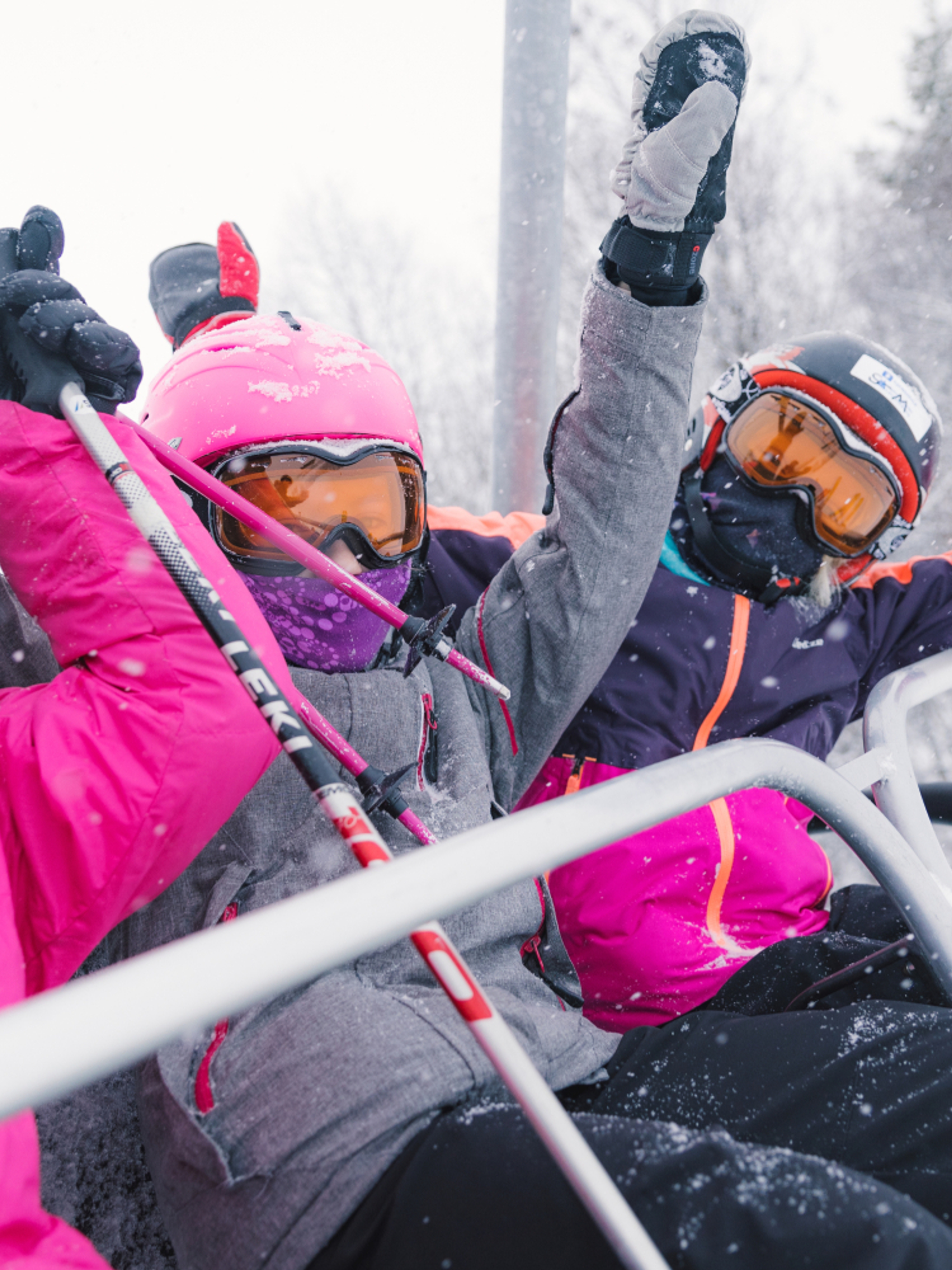 Three happy girls sitting in a ski lift in Geilo ski resort, Eastern Norway