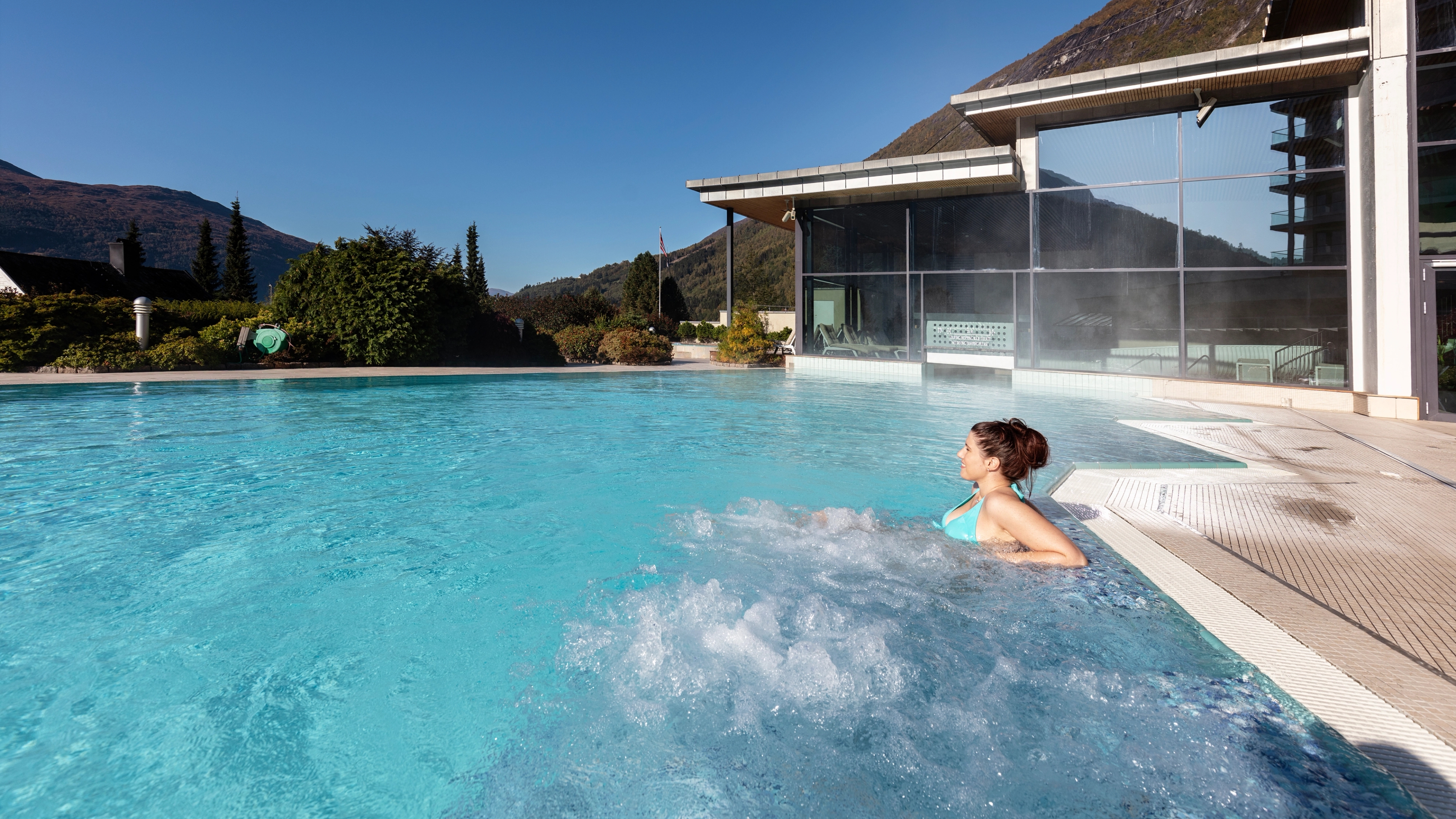 En kvinne slapper av i bassenget på Hotell Alexandra i Stryn på Vestlandet