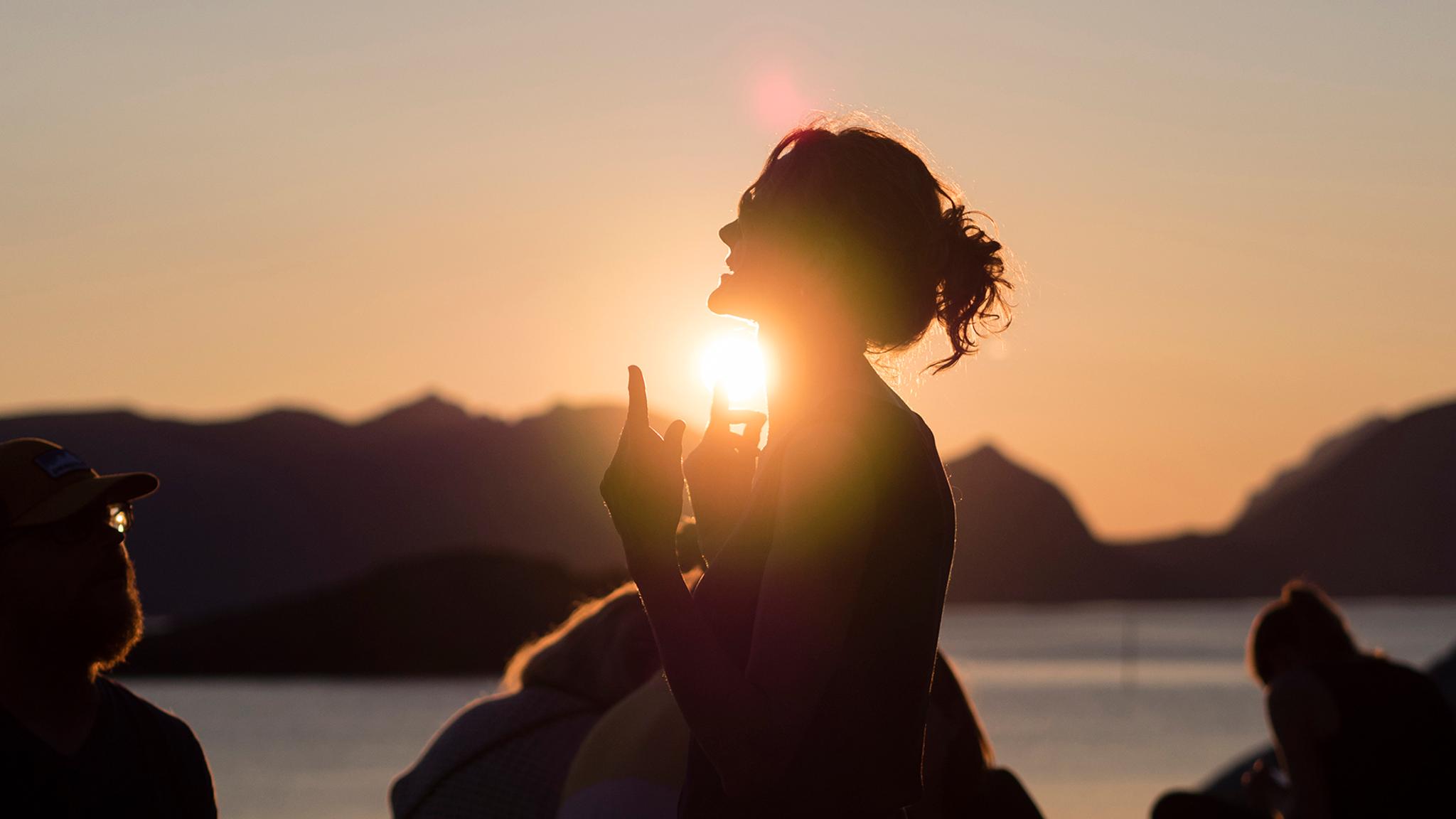 People attending the Trevarefest festival under the midnight sun in Henningsvær, Northern Norway