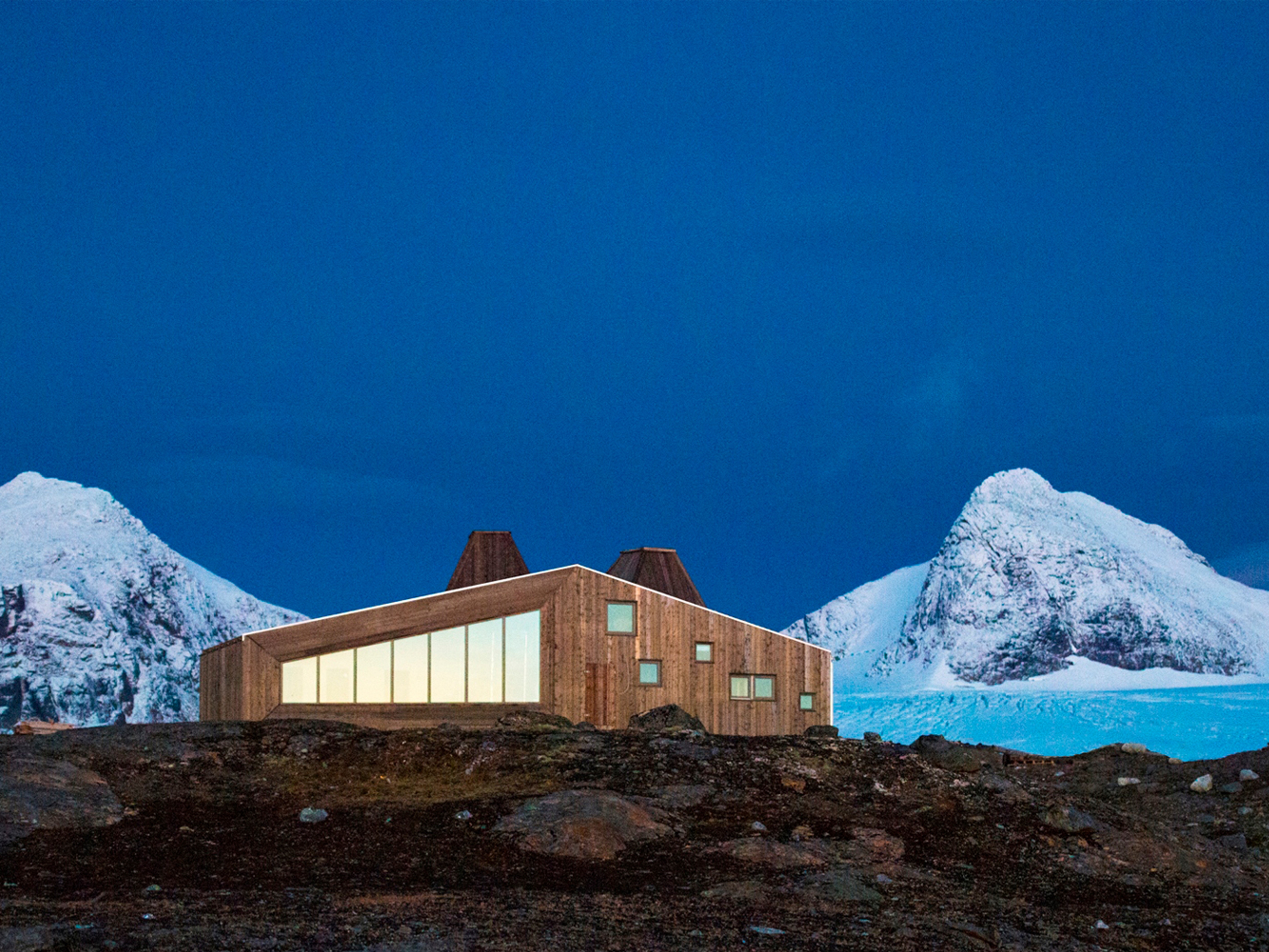 Rabothytta på Helgeland i Nord-Norge med snødekte fjell i bakgrunnen
