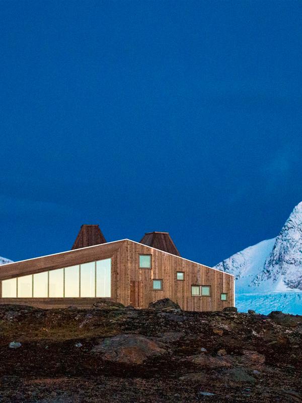 Rabothytta på Helgeland i Nord-Norge med snødekte fjell i bakgrunnen