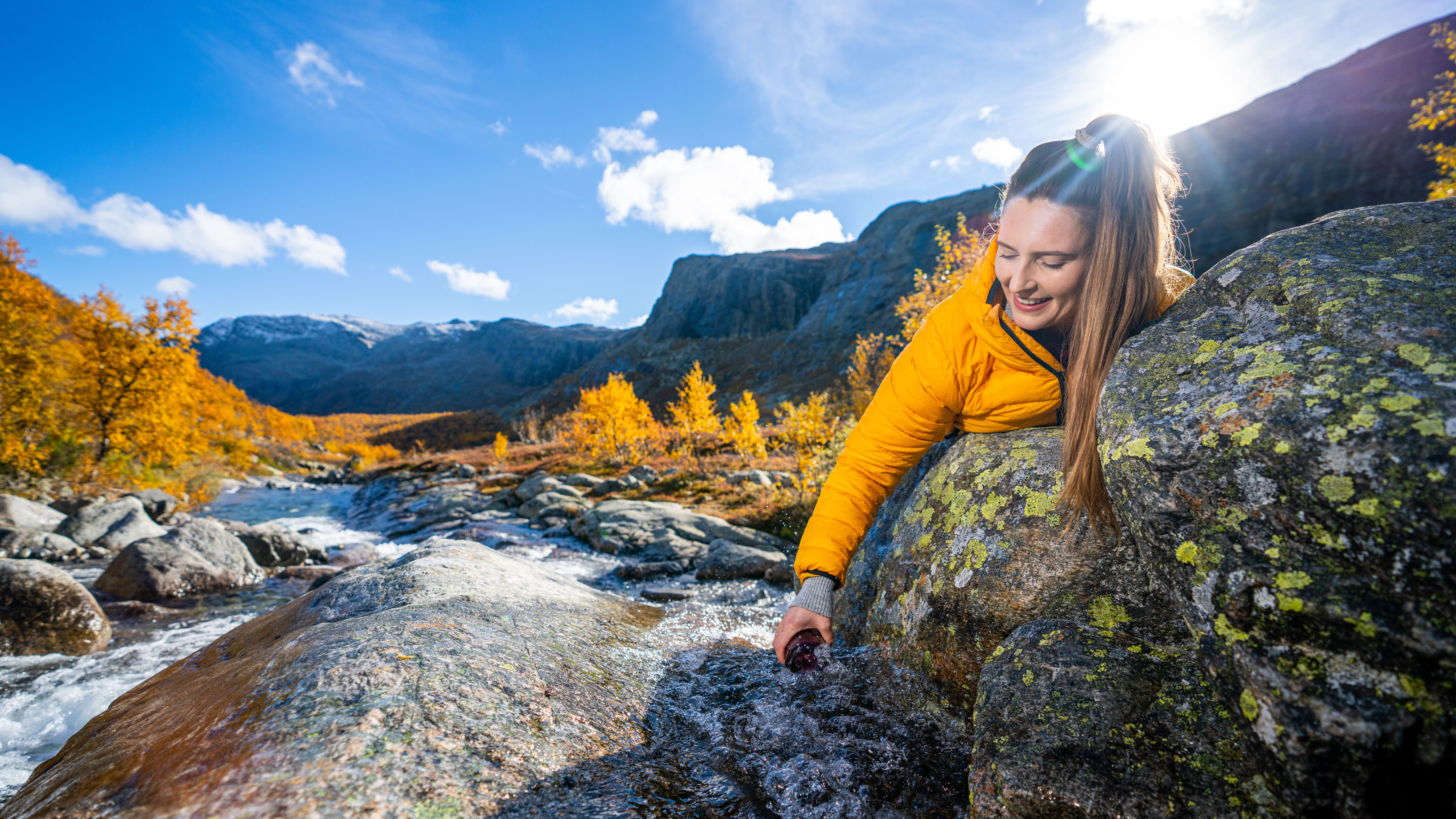 Woman drinking from a river