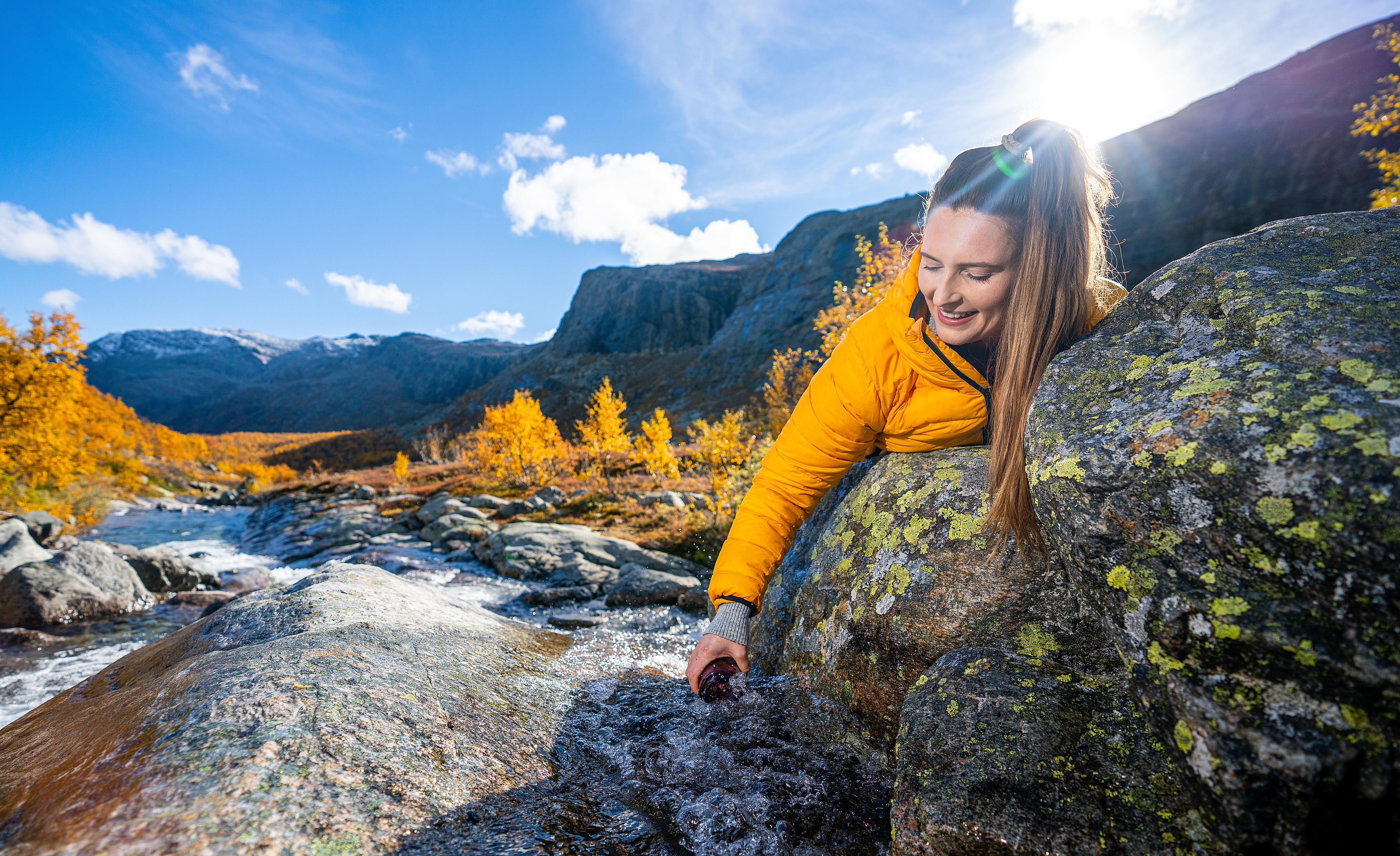 Woman drinking from a river