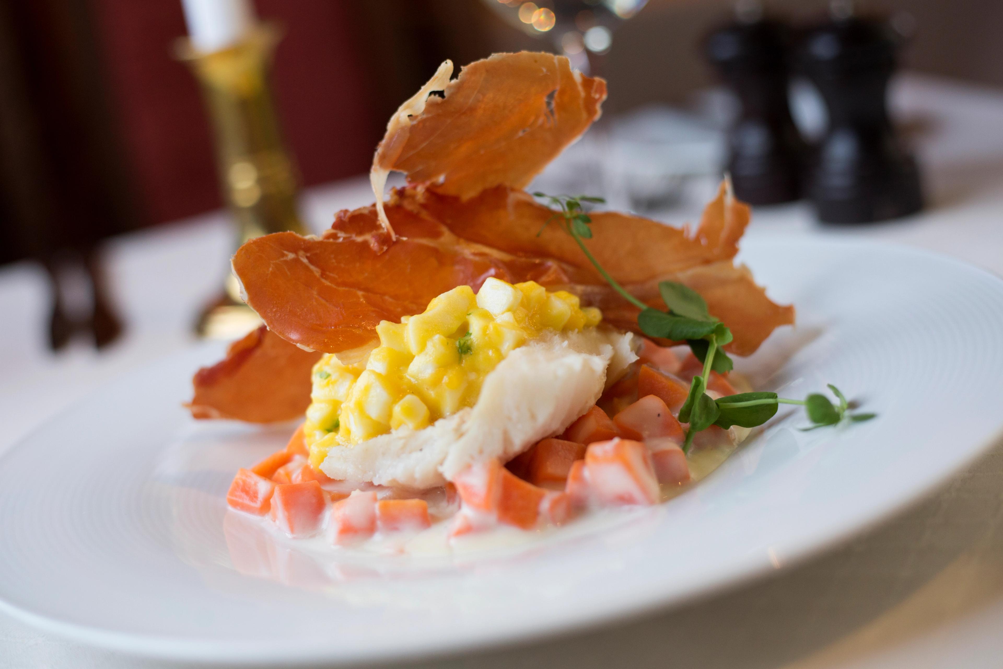 Stockfish with ham and vegetables on a plate in Lofoten, Northern Norway