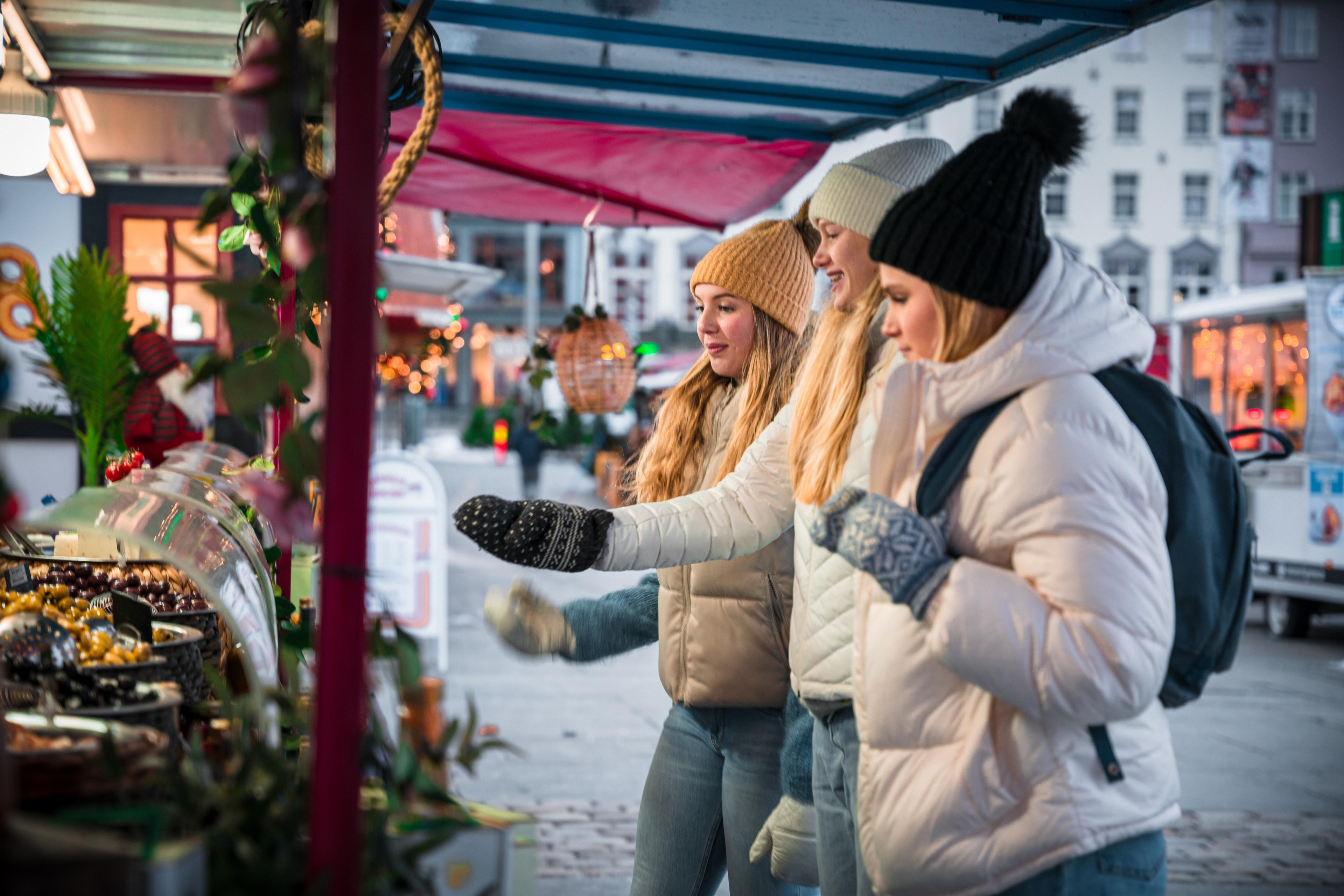 Three girls at the Christmas market in Bergen, Fjord Norway