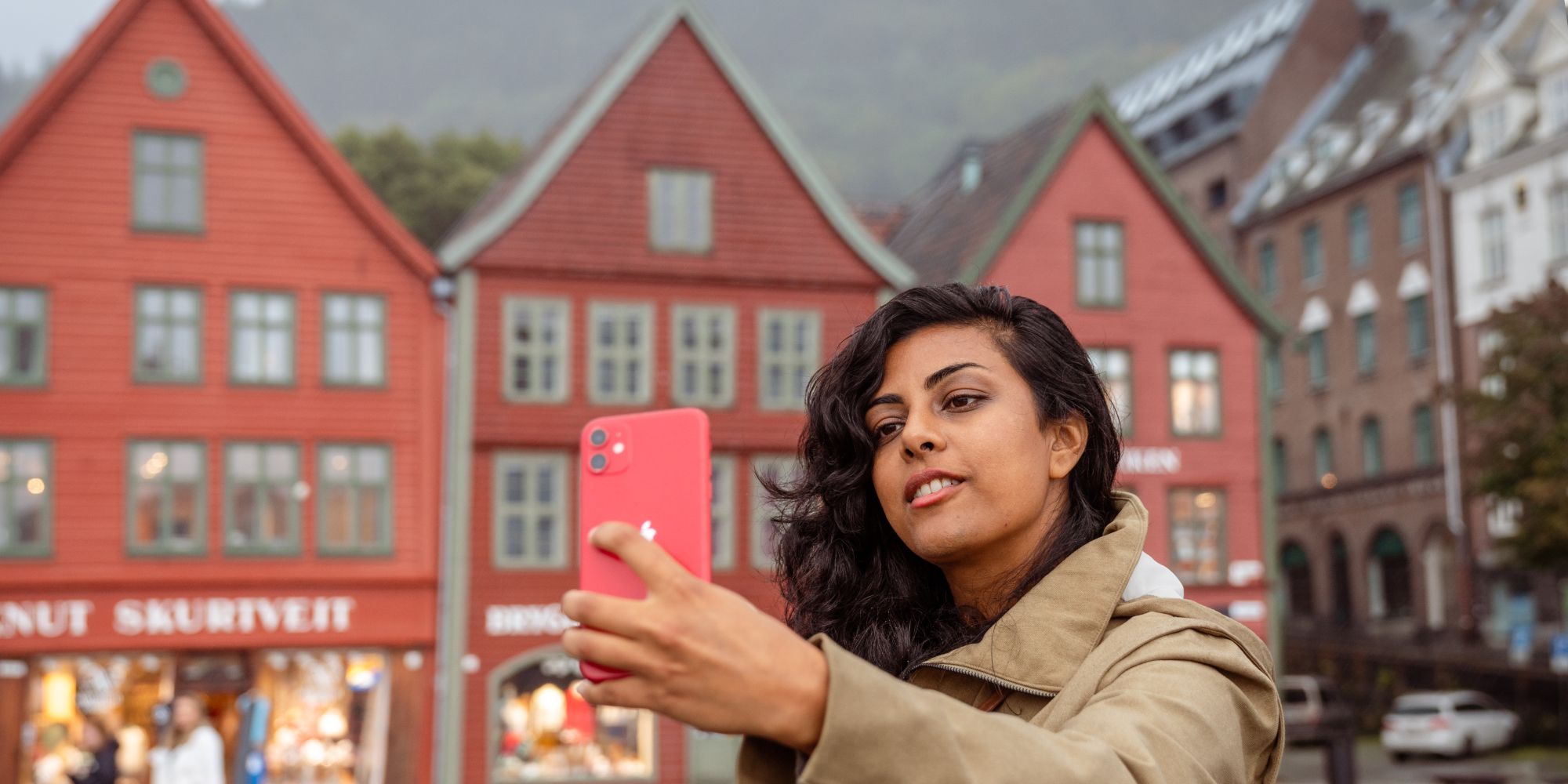 A woman on a walking tour taking a selfie at Bryggen in Bergen, Fjord Norway