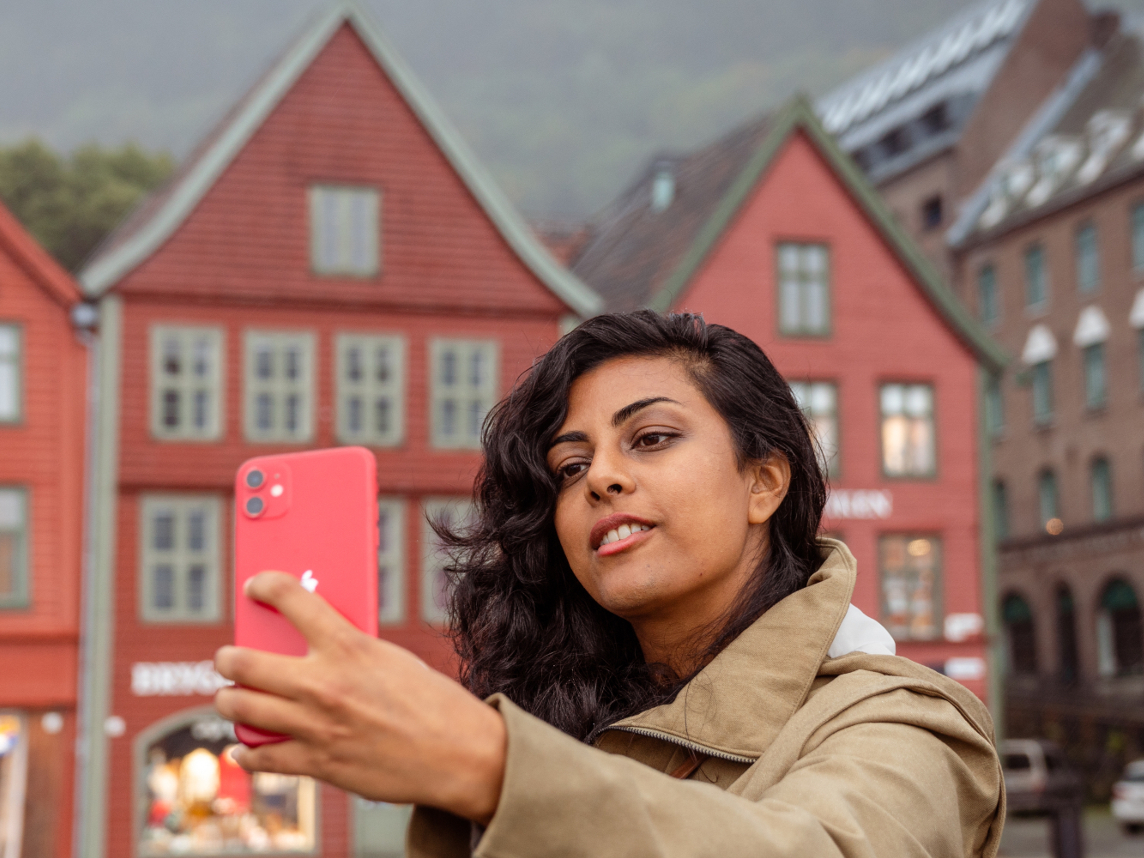 A woman on a walking tour taking a selfie at Bryggen in Bergen, Fjord Norway