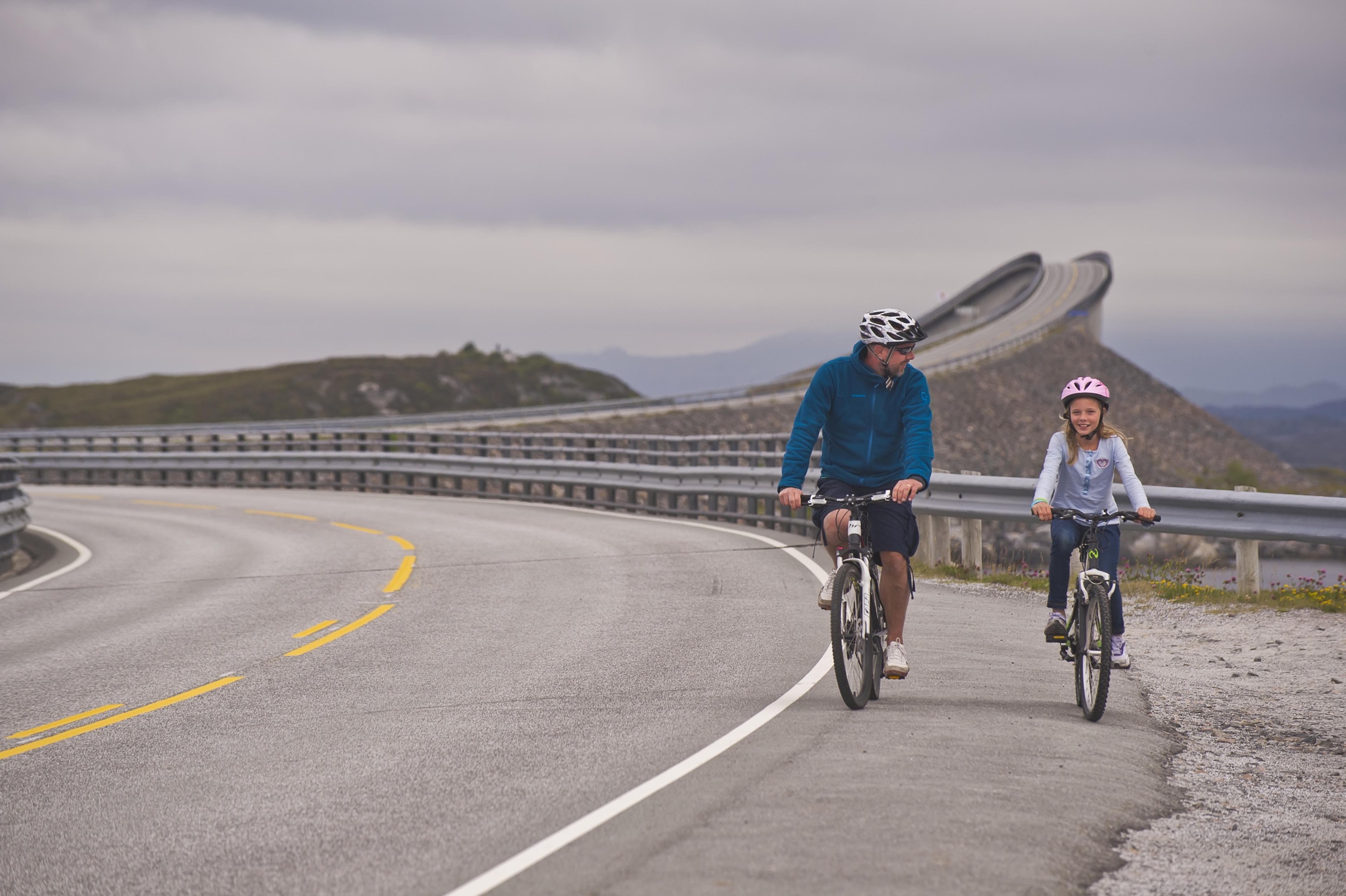 Padre e figlia in bicicletta sulla Strada Atlantica nel Nordovest dei fiordi, Norvegia dei fiordi