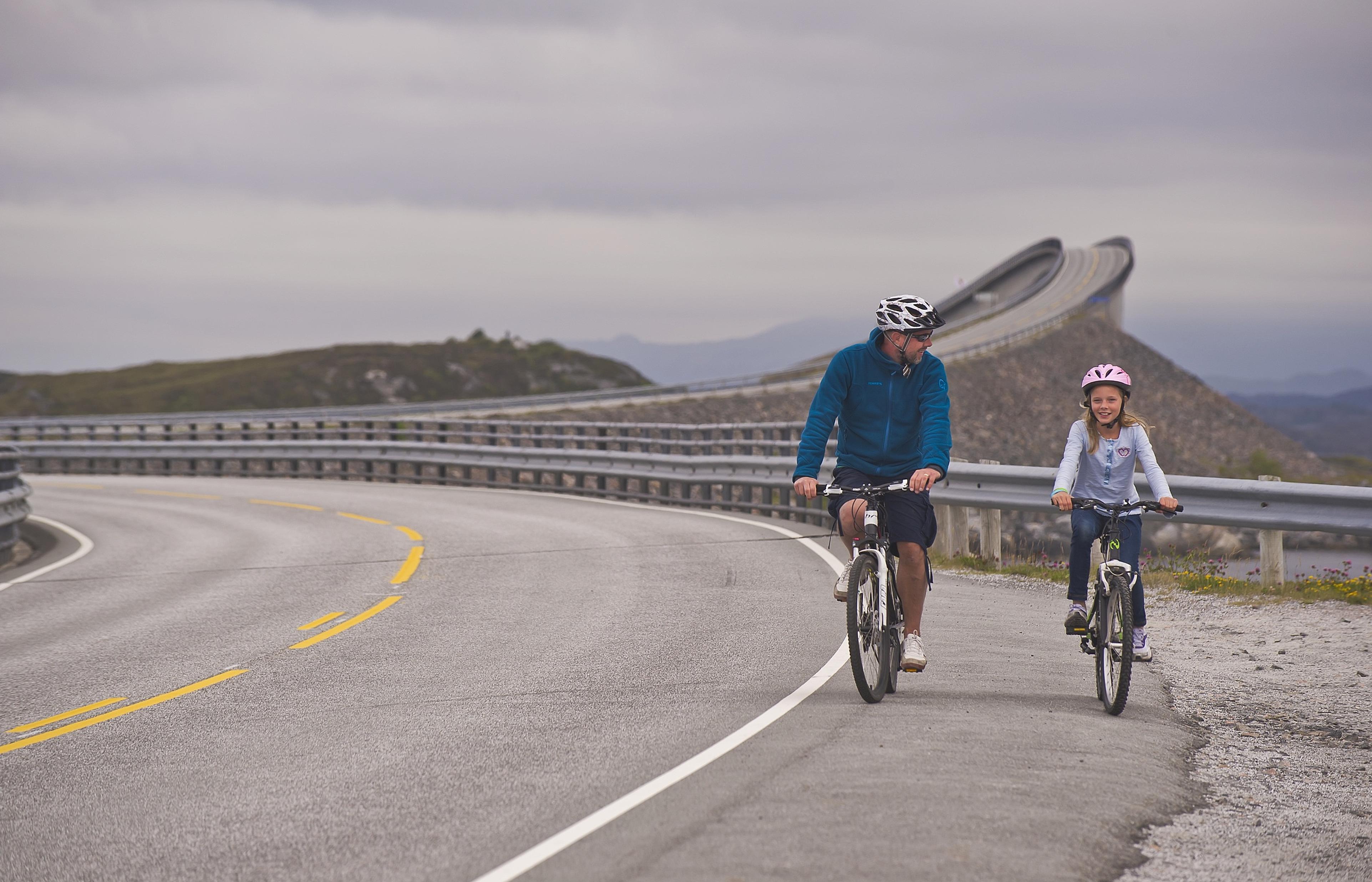 Far og datter cykler på Atlanterhavsvejen i Fjord Norge