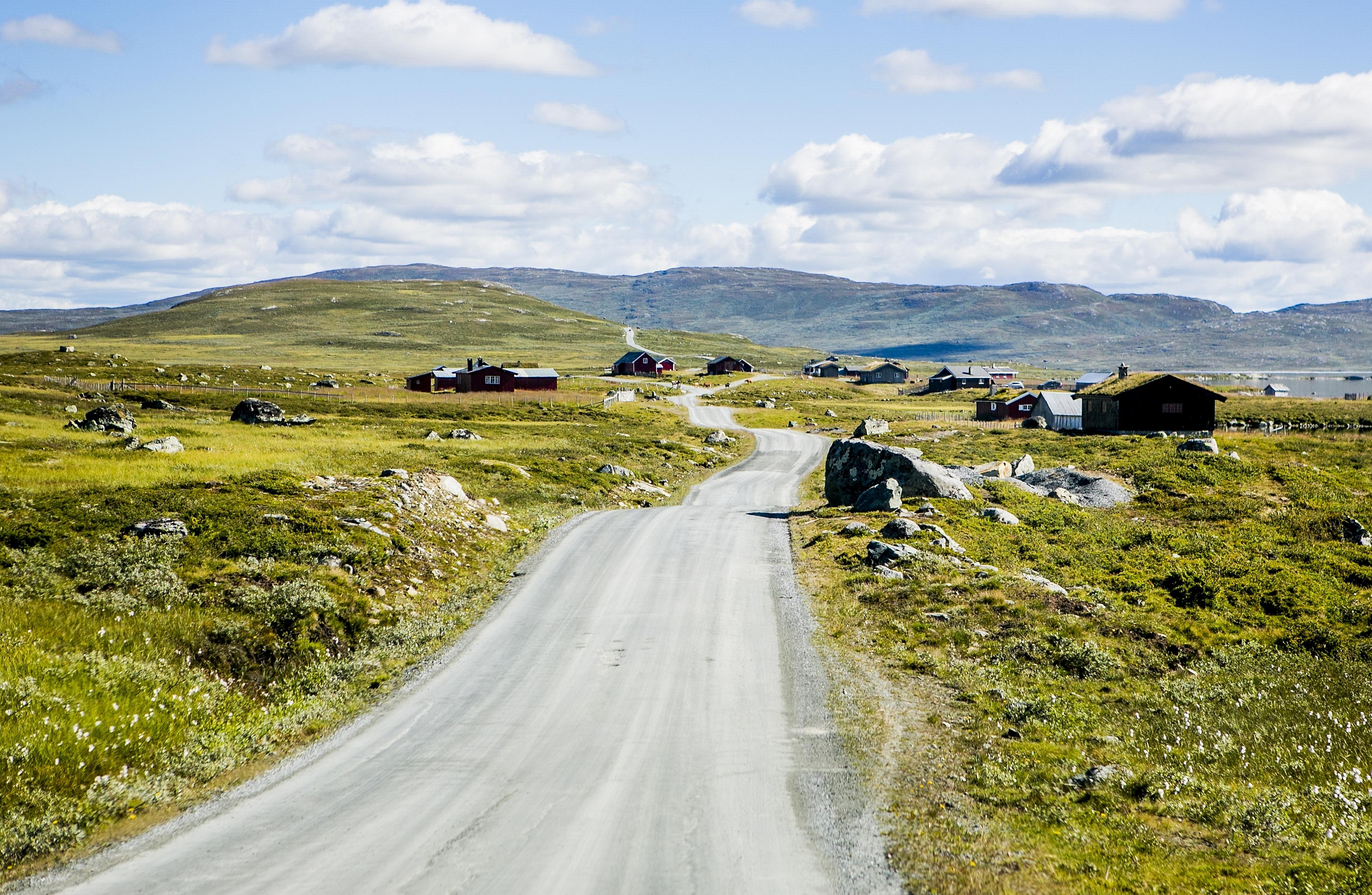 A road passing cabins in the mountains at Mjølkevegen in Valdres, Eastern Norway
