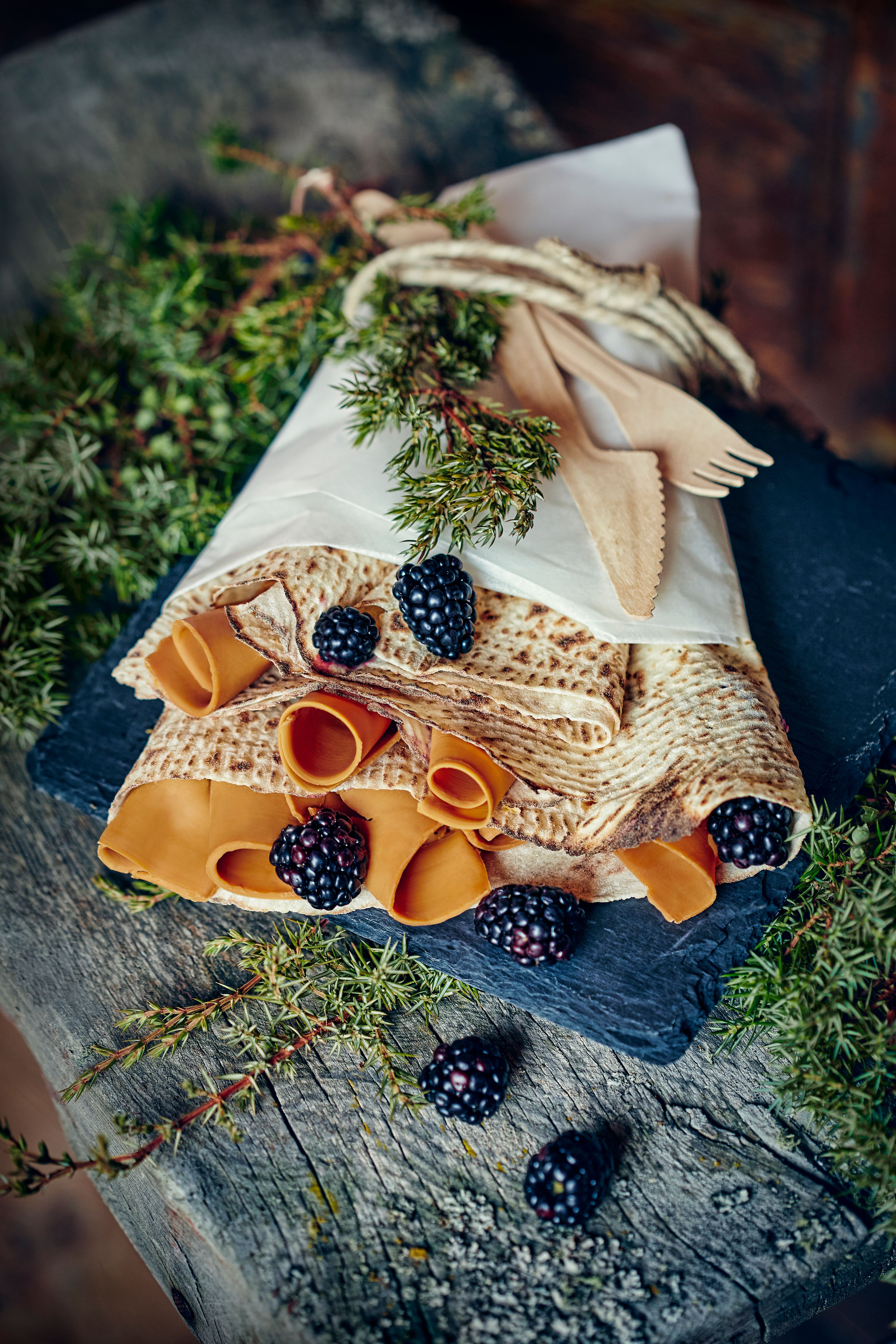 Norwegian pastry called lefse, served with brown cheese and berries