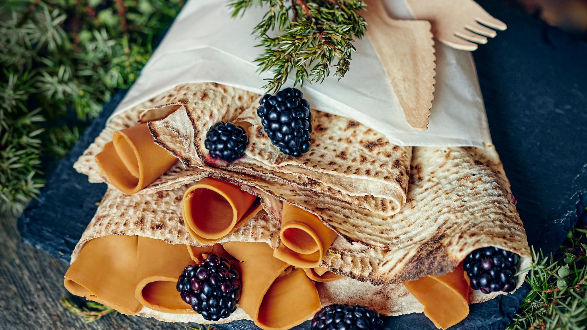 Norwegian pastry called lefse, served with brown cheese and berries