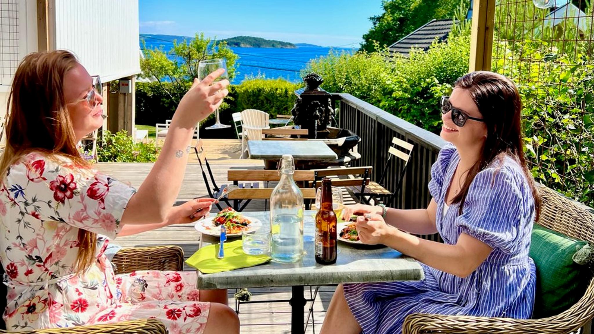 Women enjoying a meal outside at Villa Utsikten
