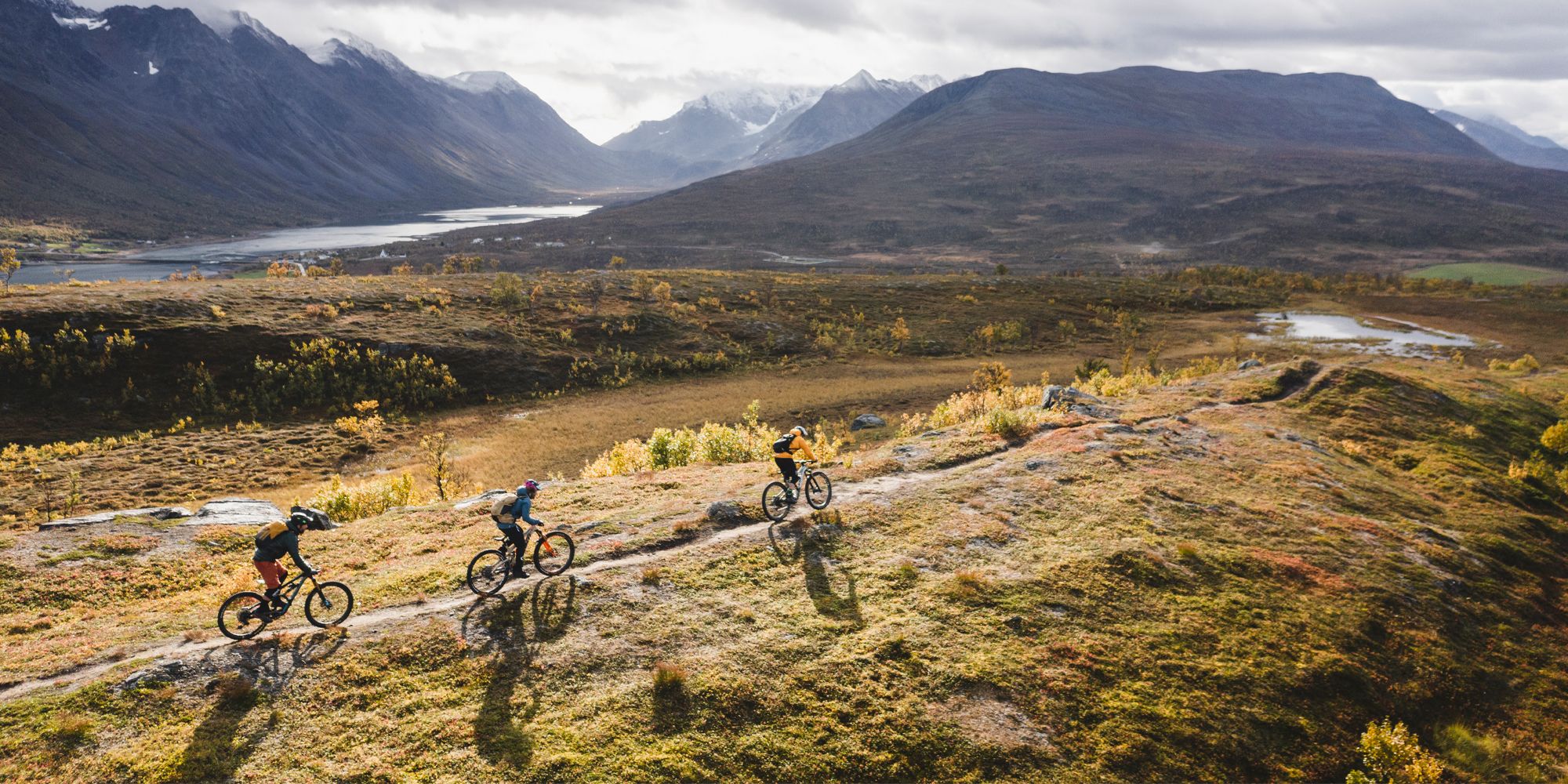 Tre personer på MTB i bergen i Lyngenfjord, norra Norge