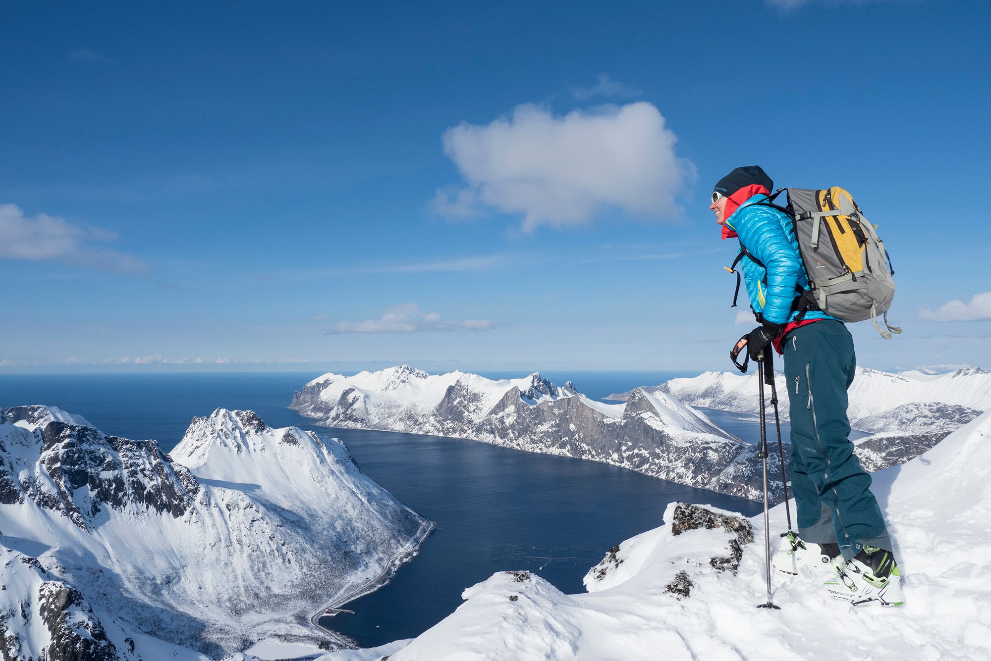 A woman standing at the top of a mountain in Senja in Northern Norway during winter