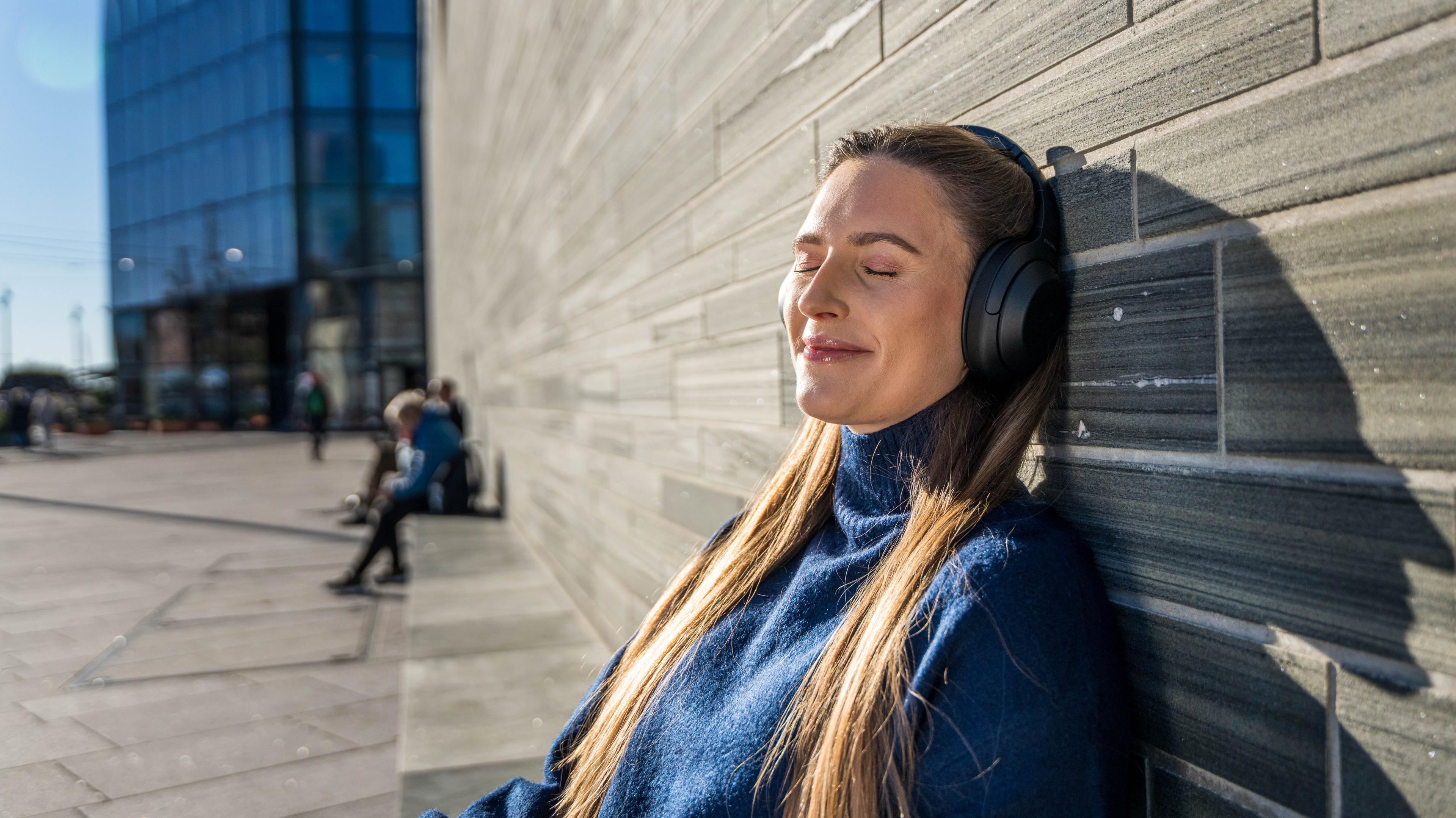 A woman listening to a podcast and enjoying the sun in Oslo