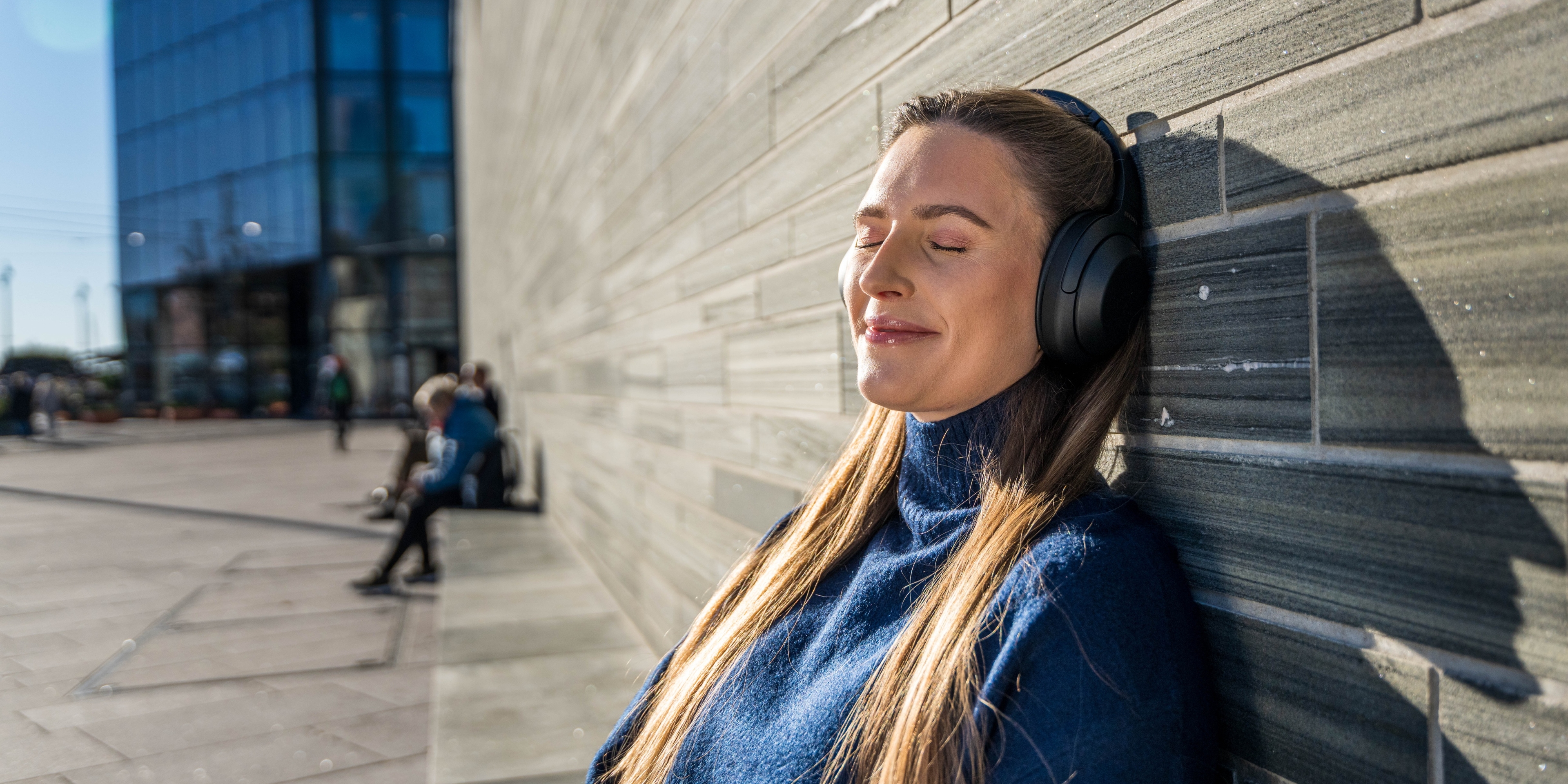 A woman listening to a podcast and enjoying the sun in Oslo