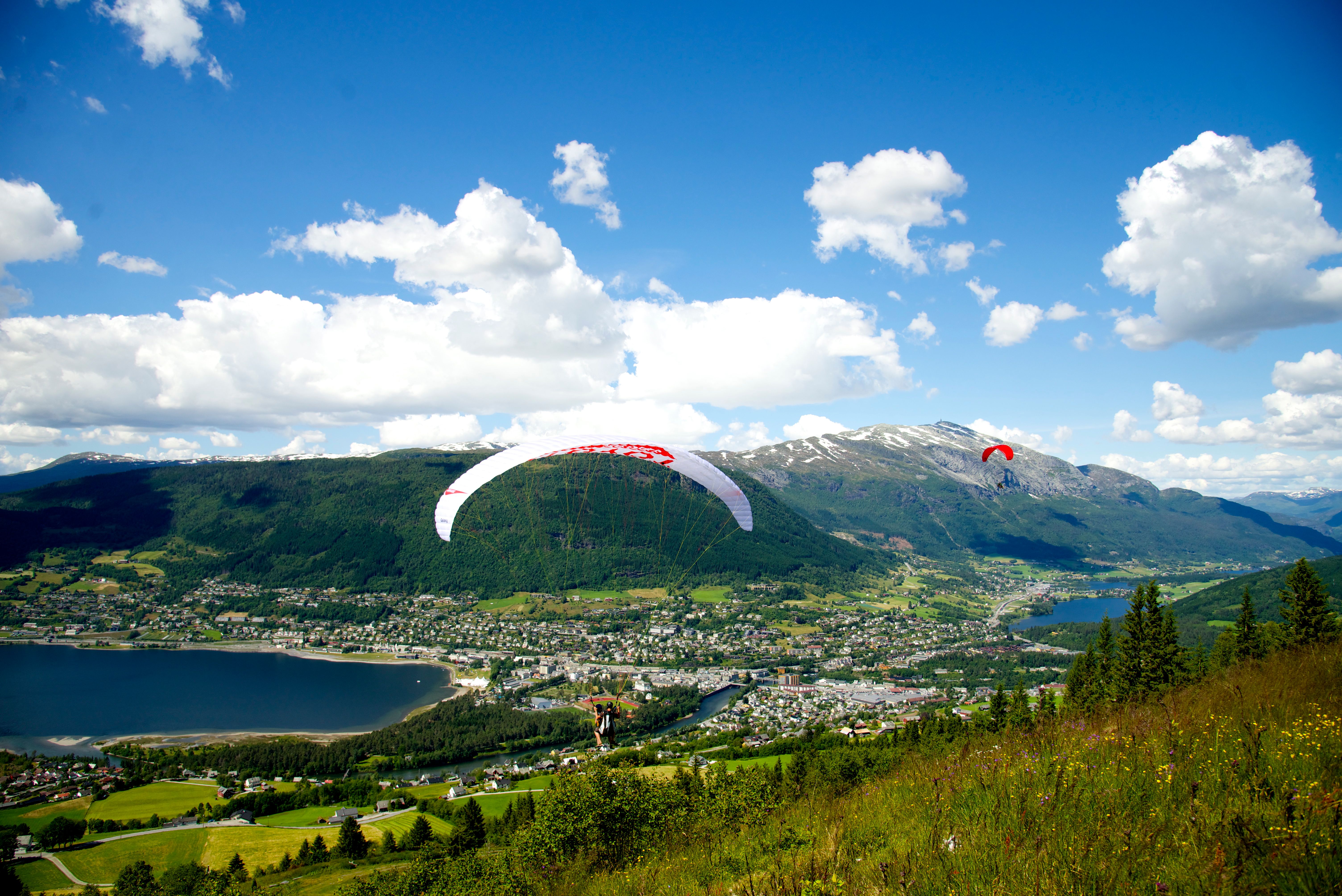 People paragliding over Voss in Fjord Norway during the Ekstremsportveko extreme sport festival