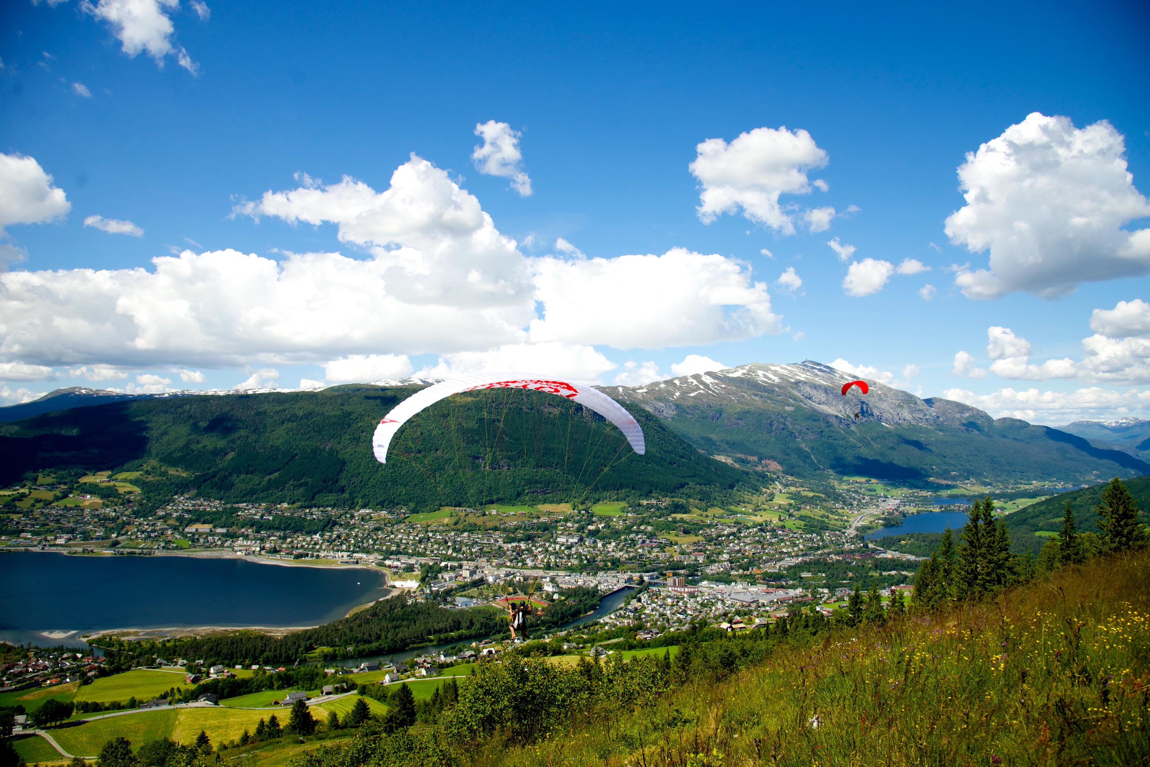 People paragliding over Voss in Fjord Norway during the Ekstremsportveko extreme sport festival
