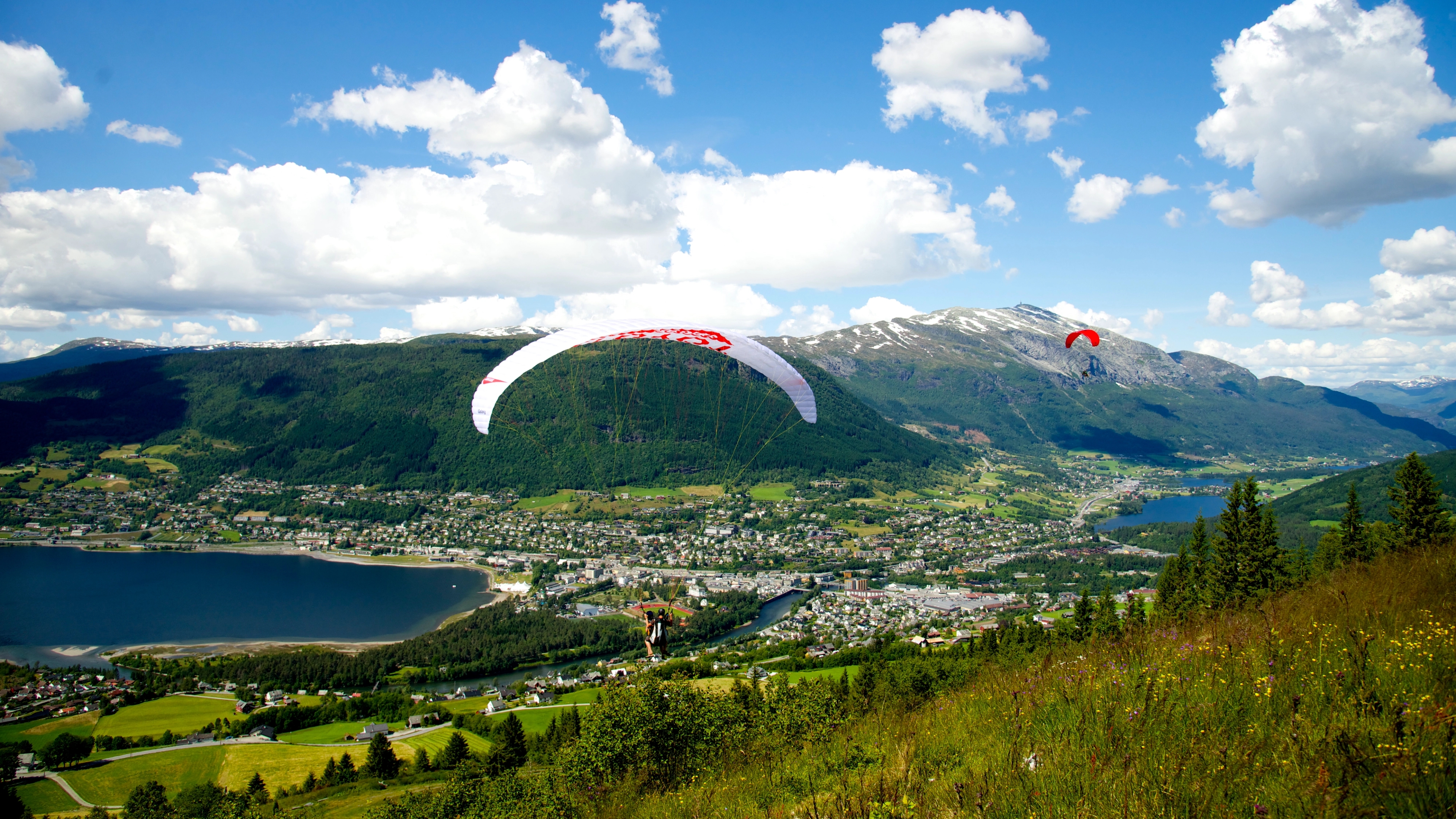People paragliding over Voss in Fjord Norway during the Ekstremsportveko extreme sport festival