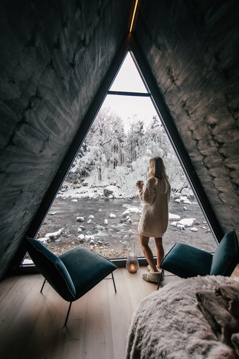 Girl looking out of River Suite window in winter at Jølstraholmen