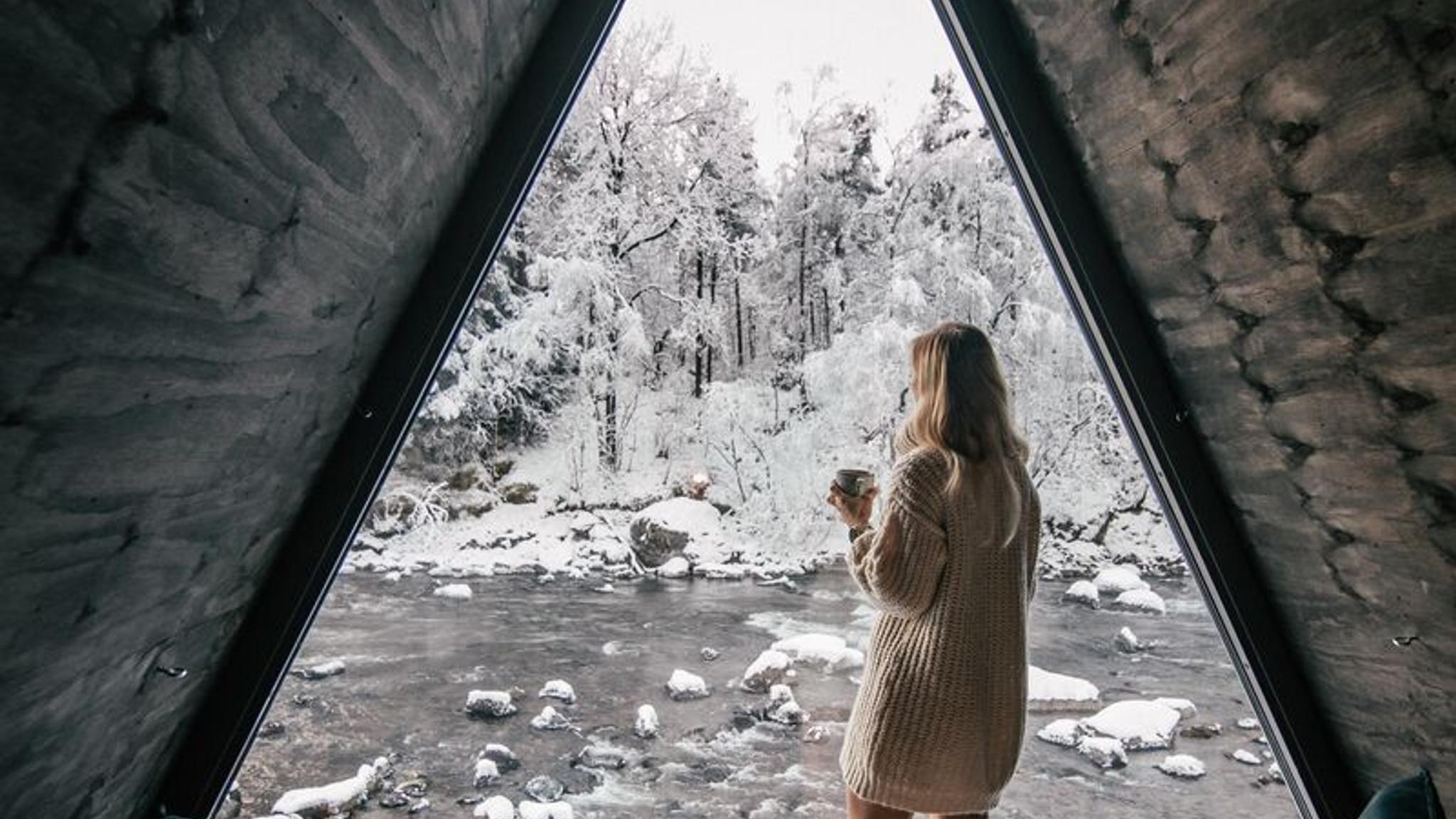 Girl looking out of River Suite window in winter at Jølstraholmen