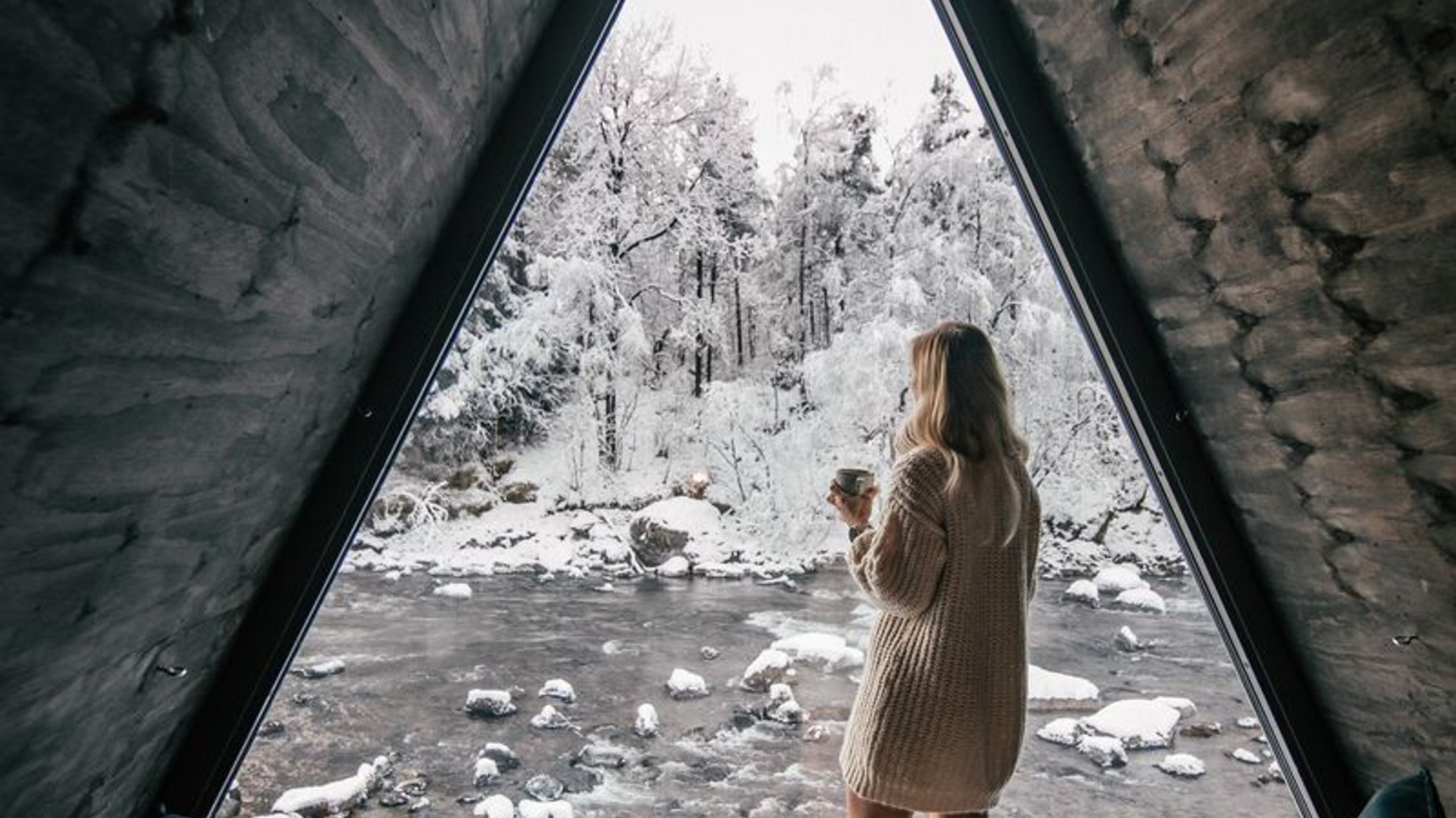 Girl looking out of River Suite window in winter at Jølstraholmen