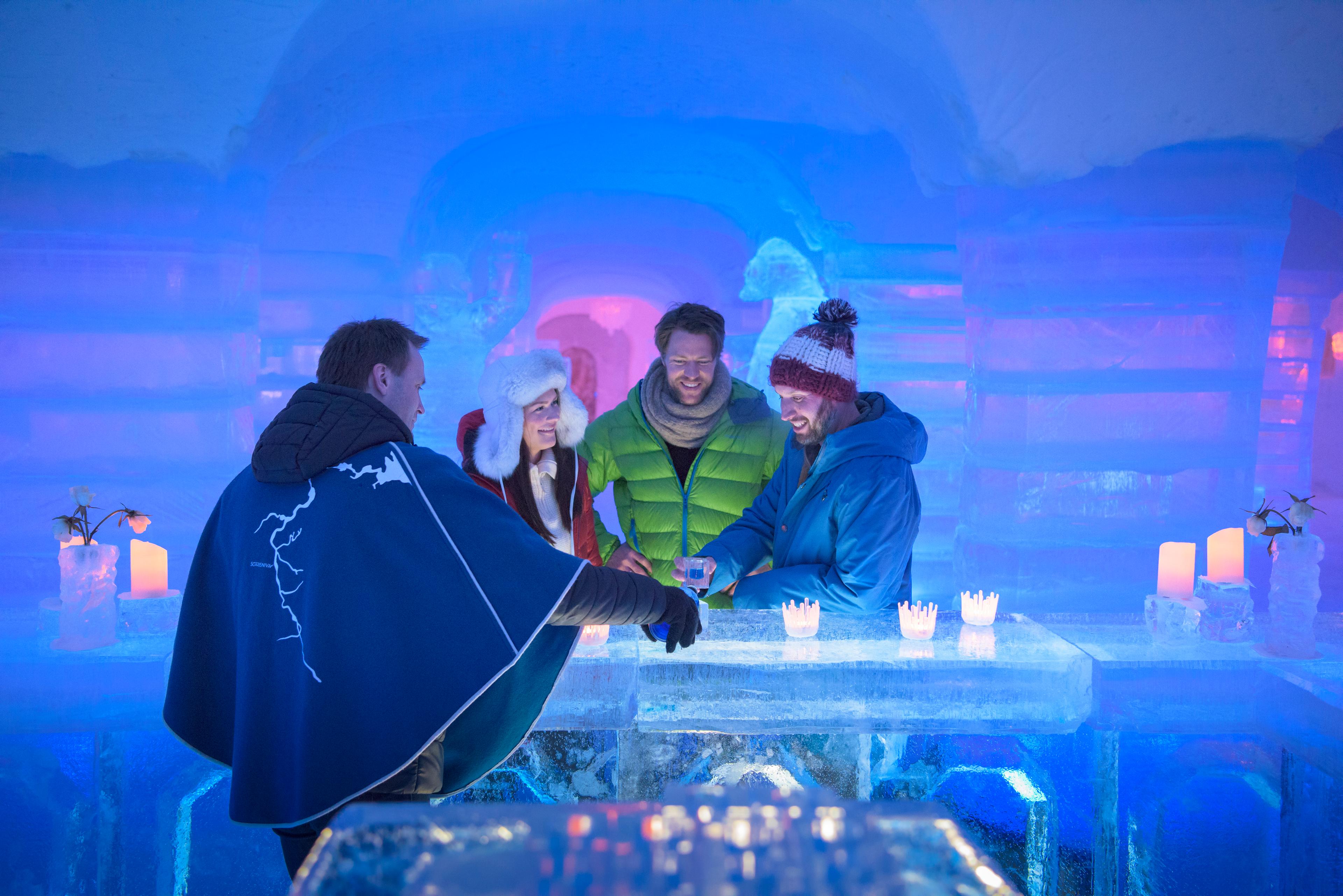 Four persons having a drink at the bar of the Sorrisniva Igloo Hotel in Alta, Northern Norway