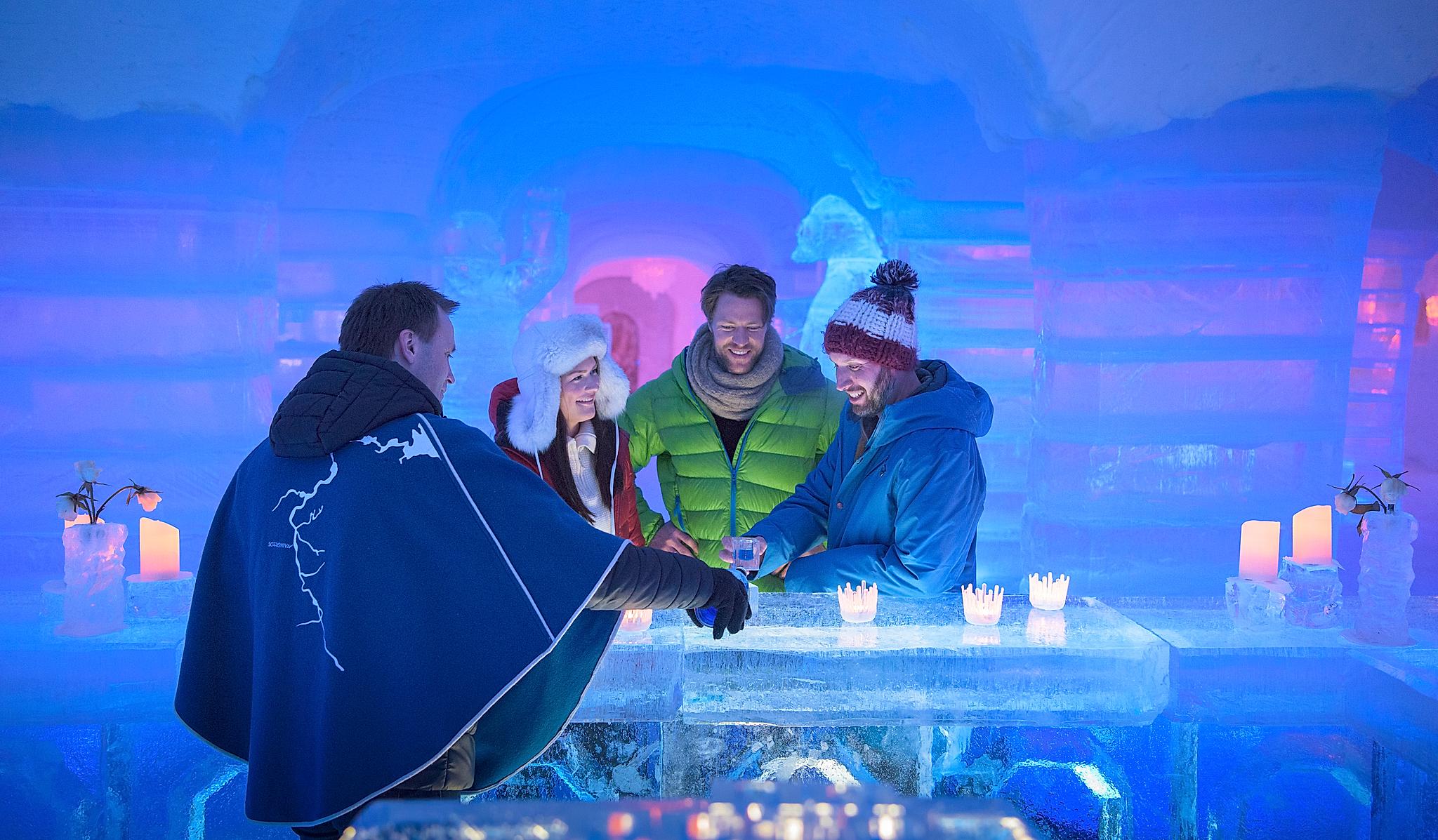 Four persons having a drink at the bar of the Sorrisniva Igloo Hotel in Alta, Northern Norway